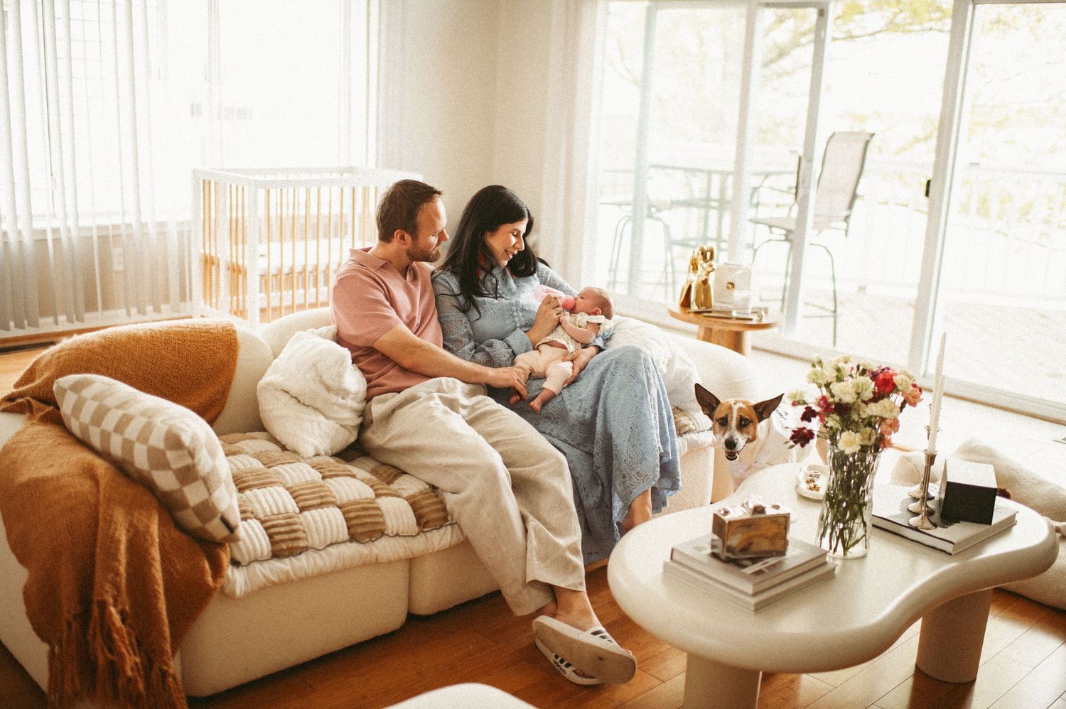 New parents sitting on their couch in their Norfolk home looking at their newborn baby girl.