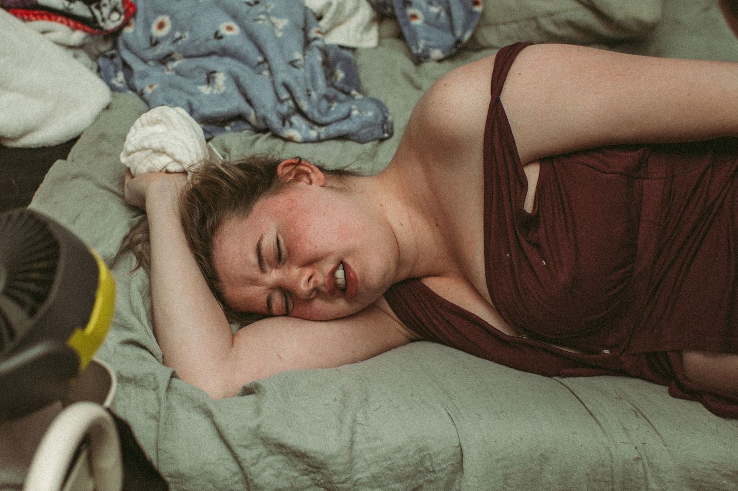 Virginia laboring mom trying to push through an intense contractions while laying in bed on her side.