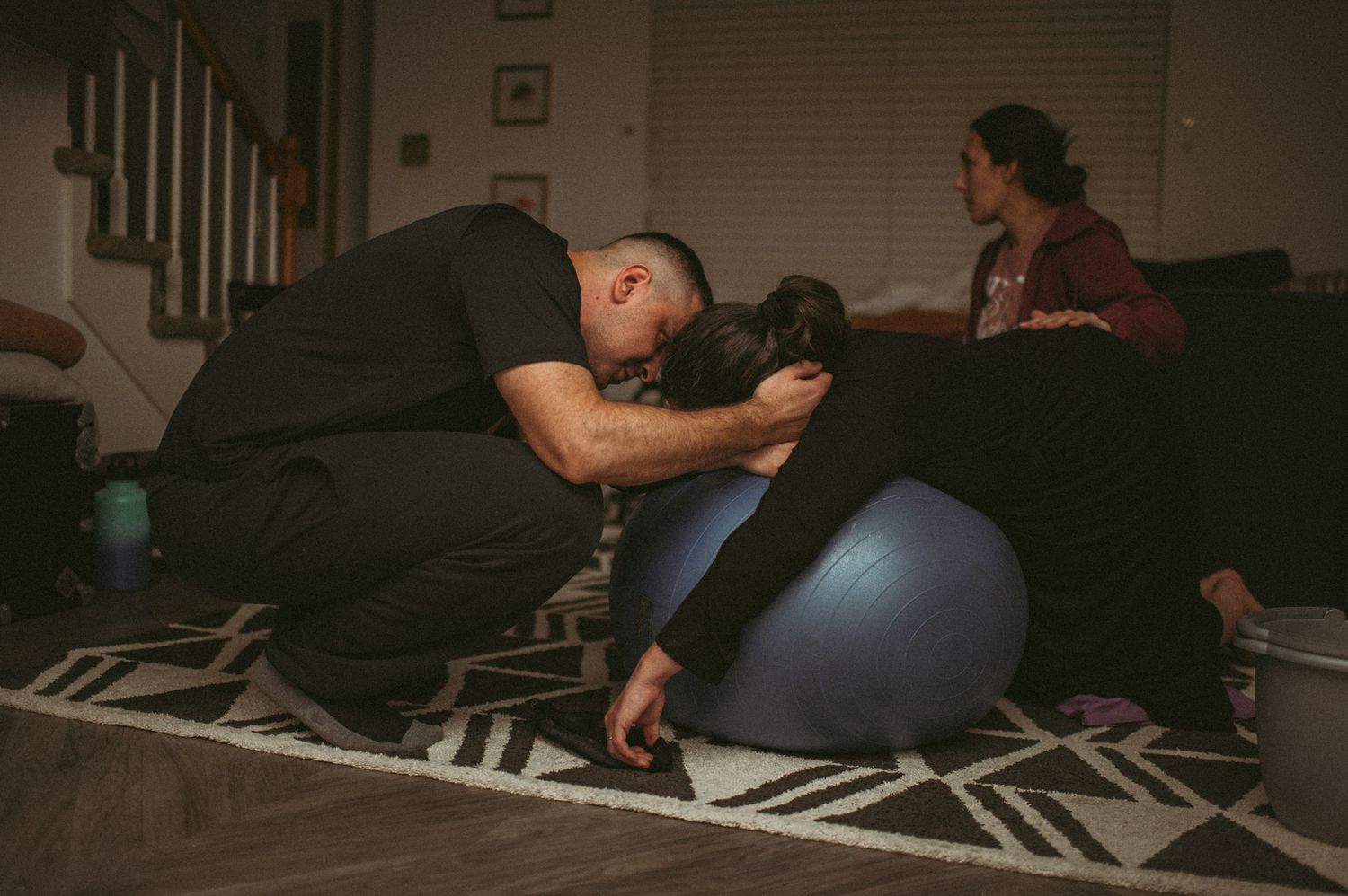 Hampton couple sharing a sweet moment during a break from contractions in their living room.