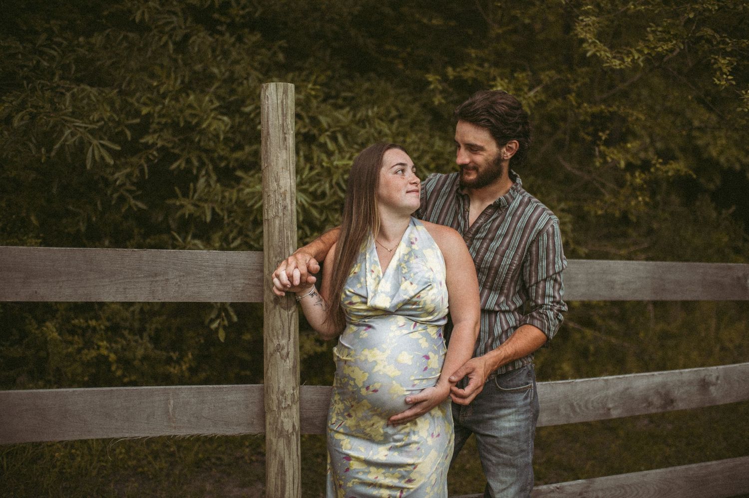 Expecting couple posing for a maternity photographer on their property in Suffolk, Virginia.
