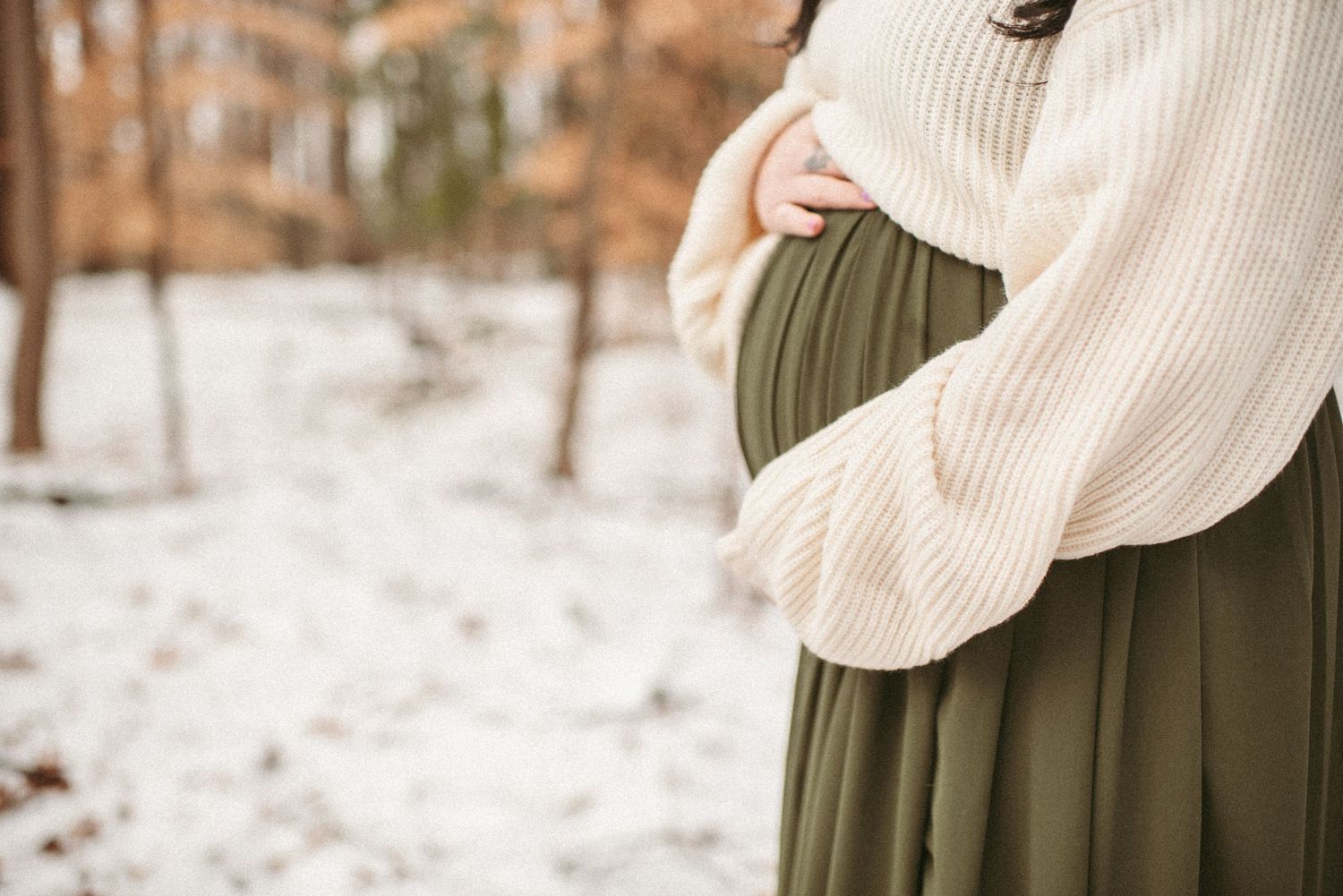 Suffolk mom posing in the snow for her maternity session.