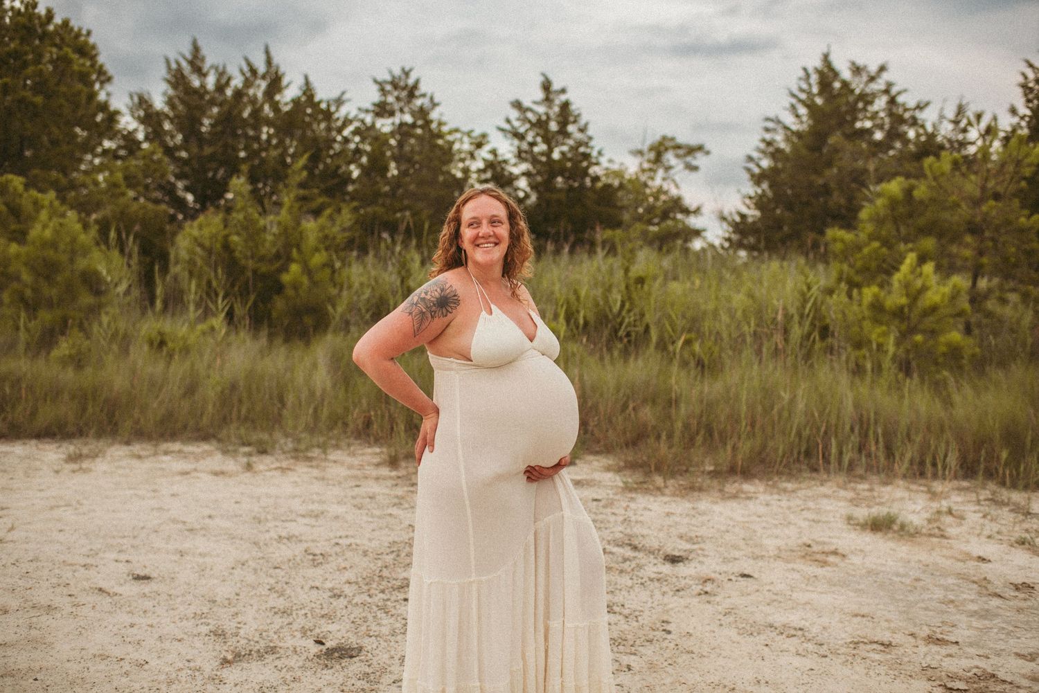 Local Virginia Beach mother posing for the camera in a sandy wooded area.