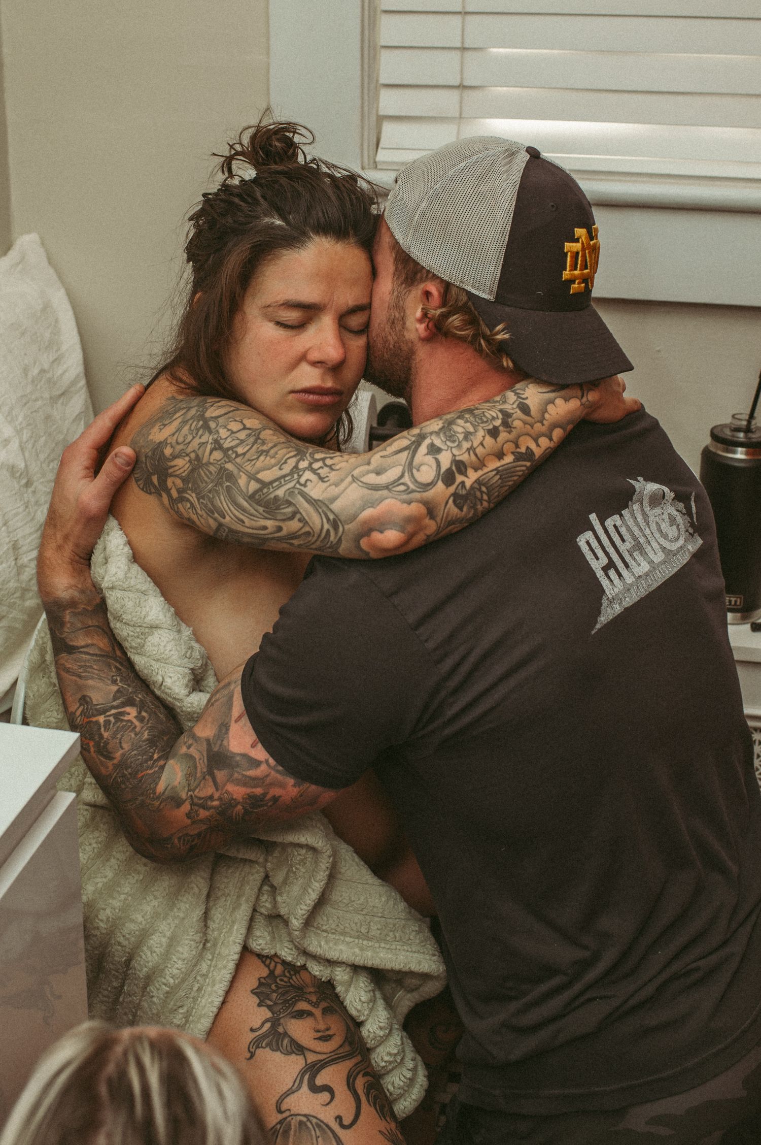 Norfolk couple embrace for support through an intense contraction in their home bathroom.