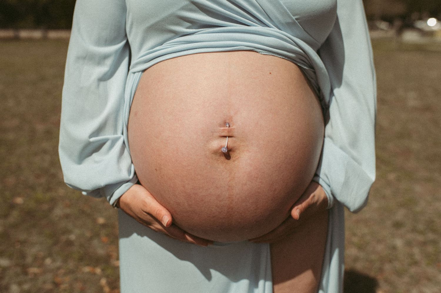 Va Beach expecting mom showing pregnant belly during maternity session.