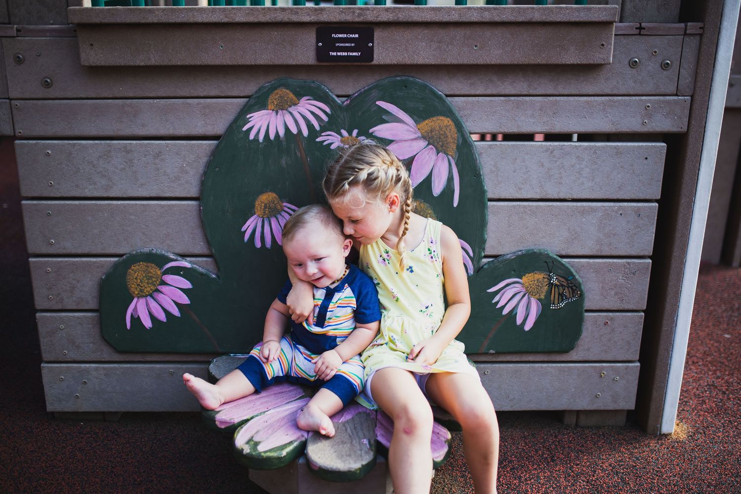 Sister and brother share a hug at a local playground.