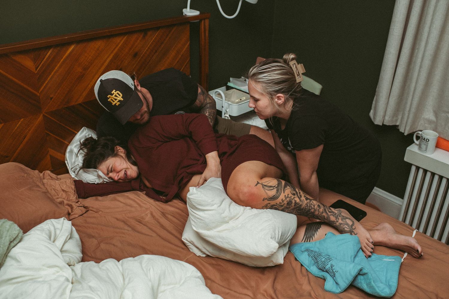 Husband and doula support laboring mom while she has strong contractions in their Norfolk, Virginia home.
