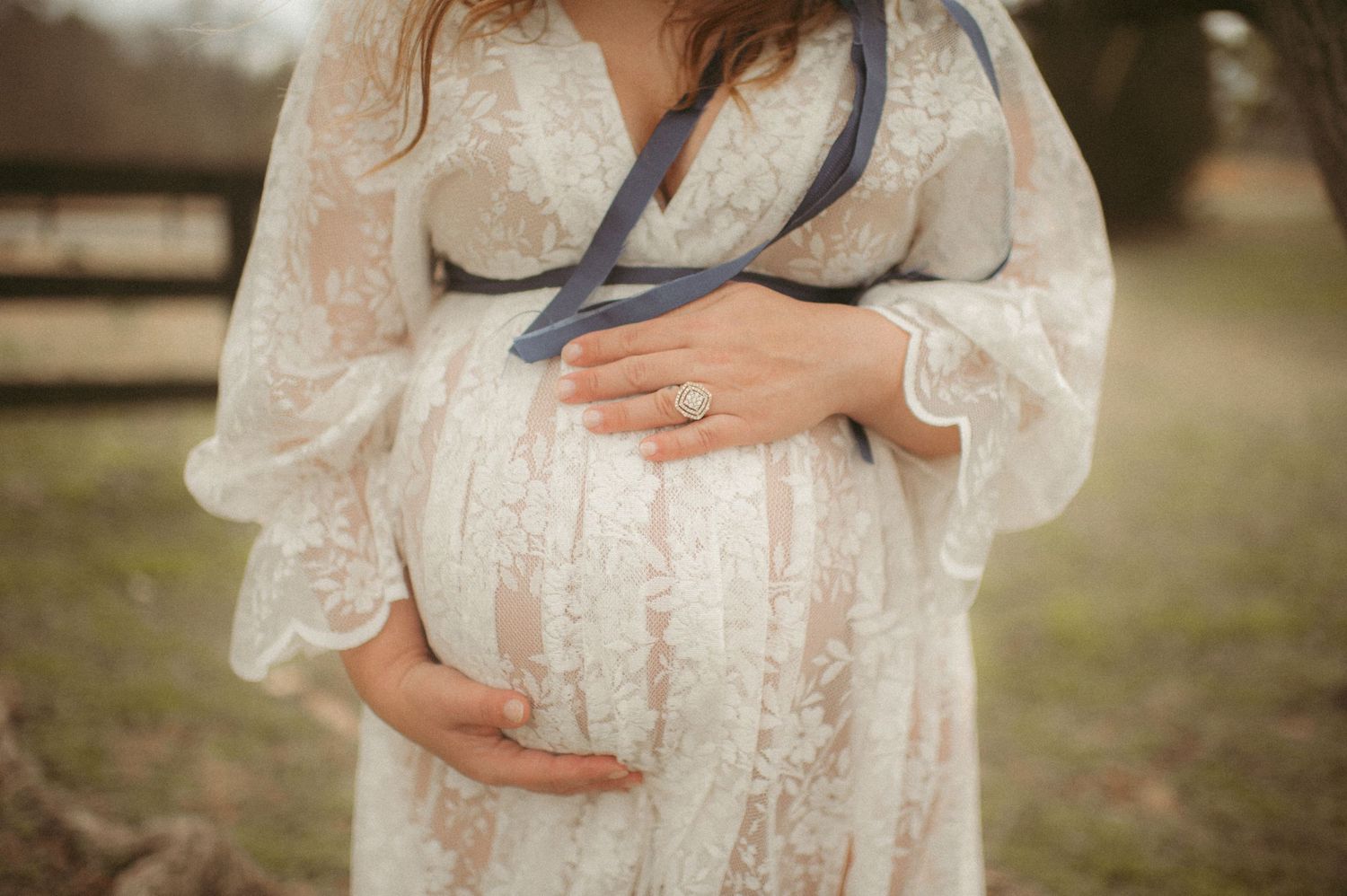 Expecting Gloucester mother holding her pregnant belly at a local state park.
