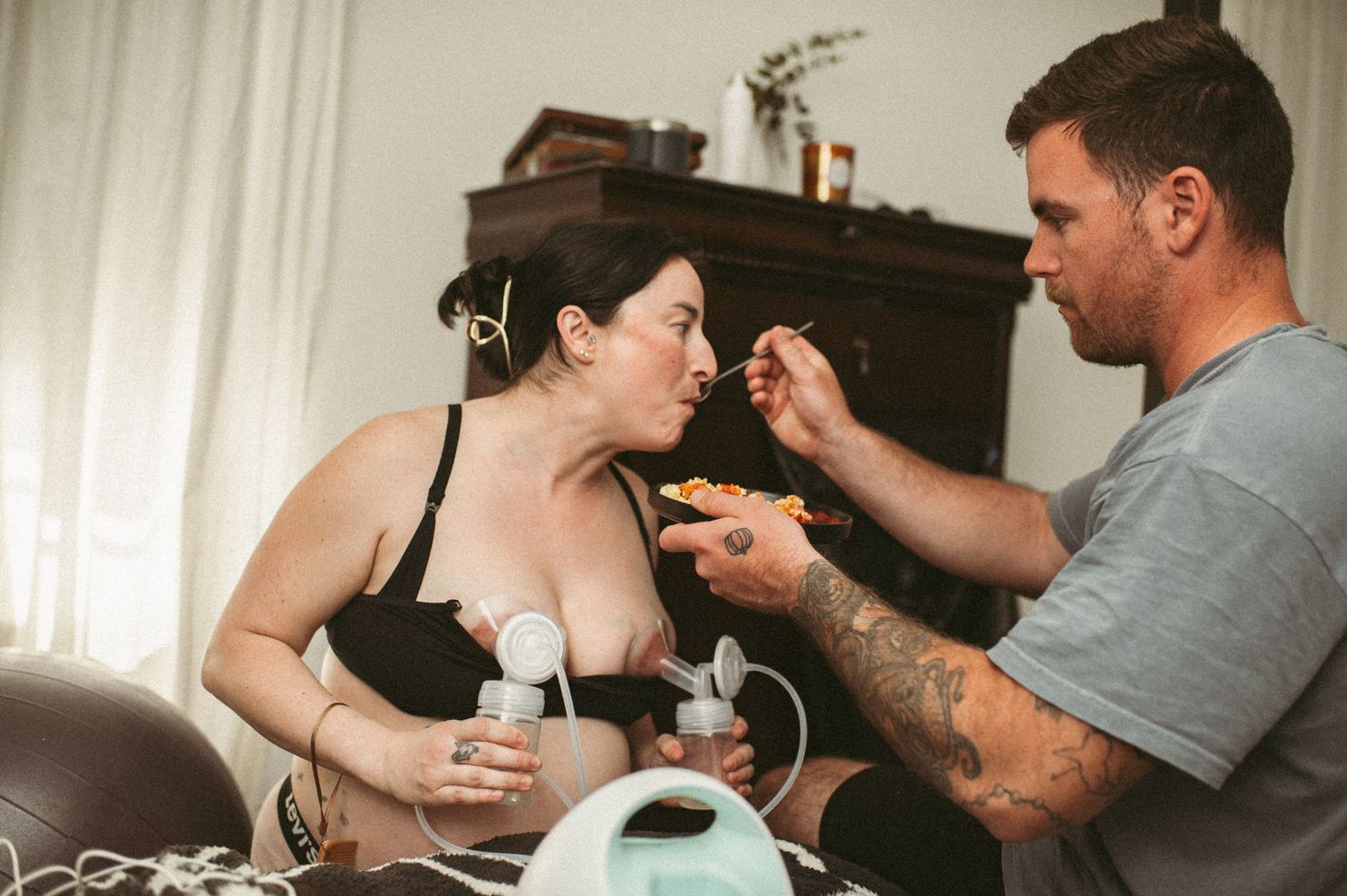 Husband feeds his wife castor oil eggs while she pumps to try and get her contractions to speed up and be more productive in there VA home.
