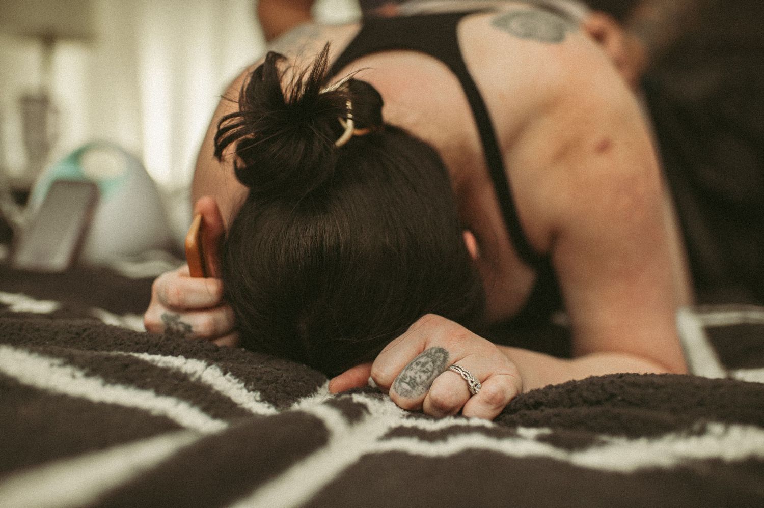 Laboring mom grabs blanket on bed while having a very strong contraction in her bedroom in Suffolk, Virginia.