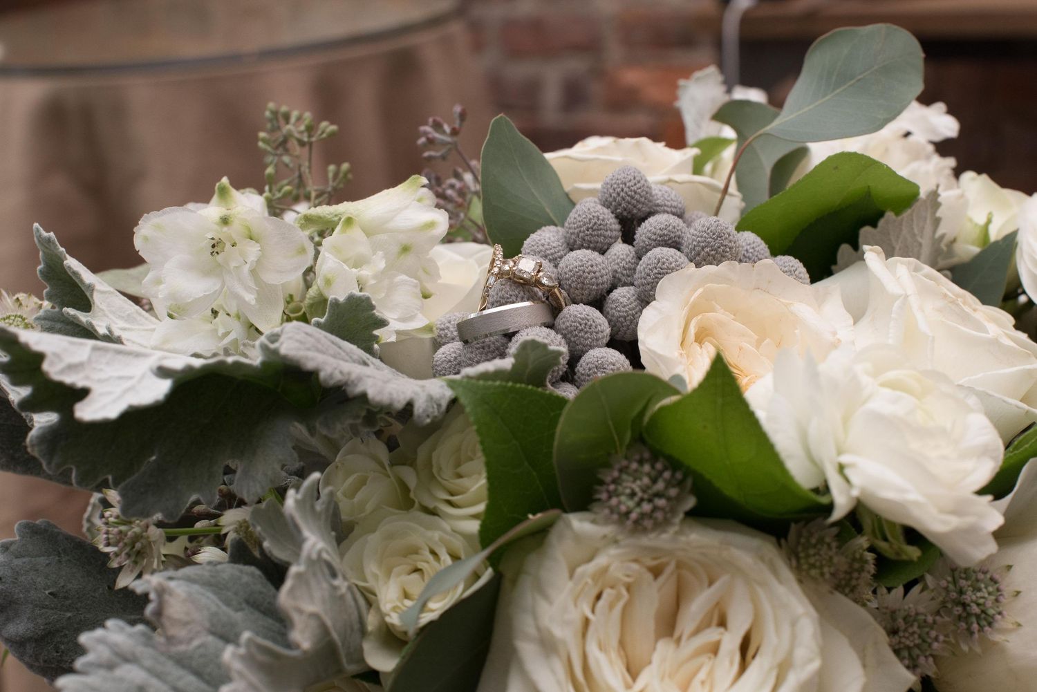 Elegant wedding bouquet with white roses, eucalyptus, and silver brunia berries.