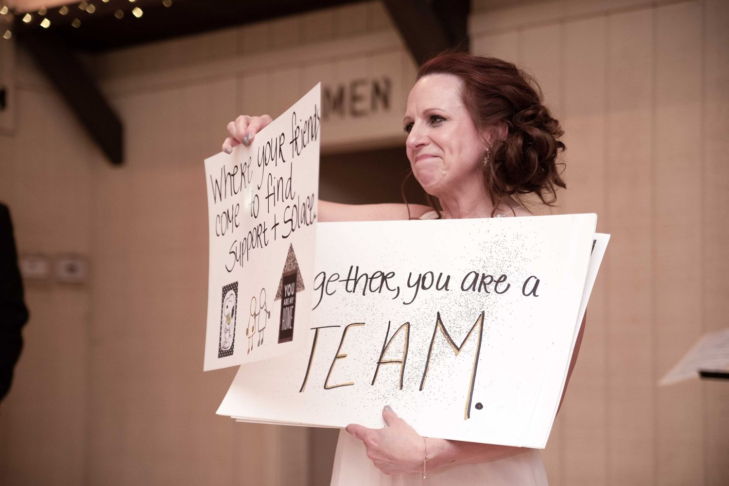 Woman holding handmade wedding signs reading 