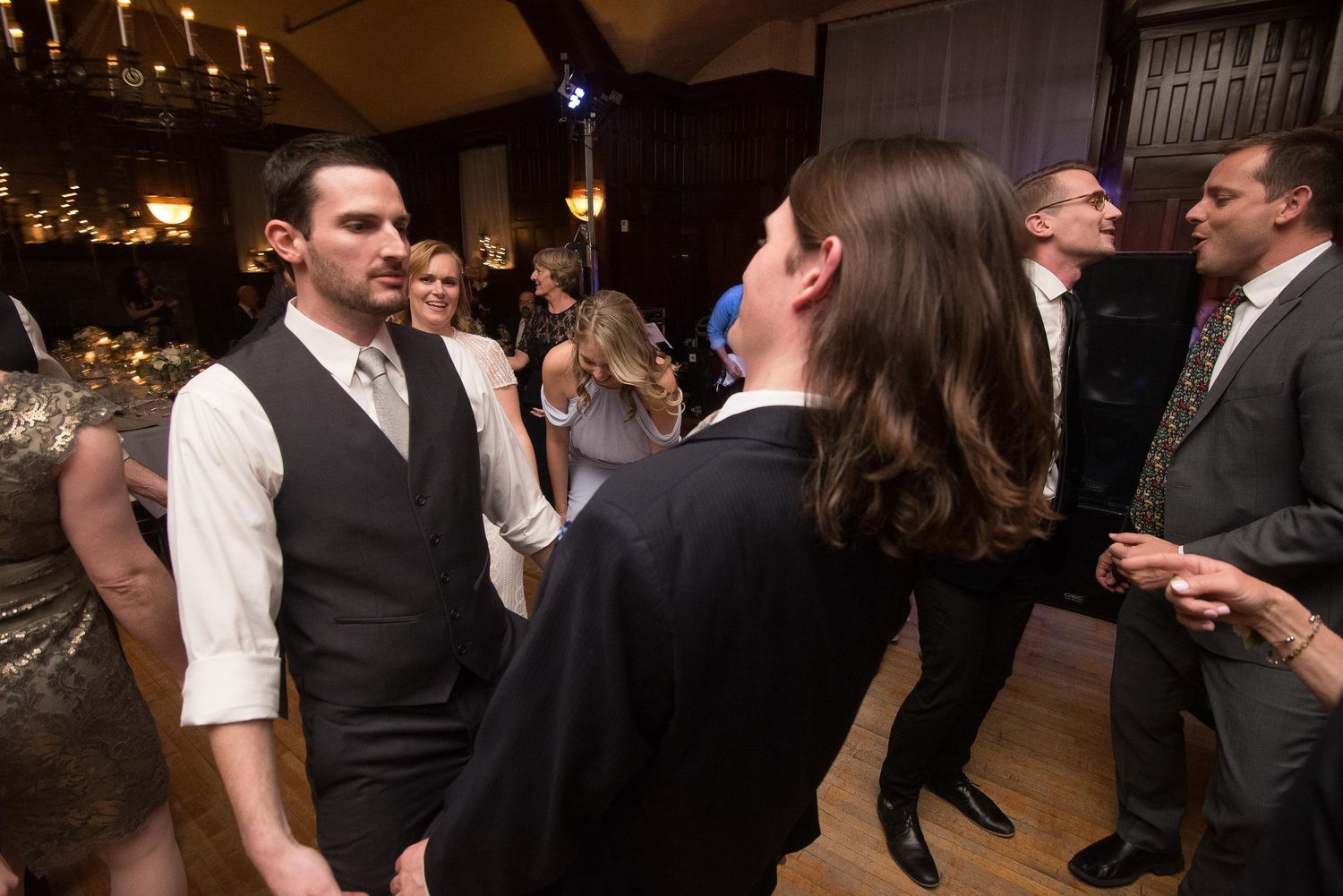 Guests mingling and dancing at an elegant formal event in a warmly lit ballroom.