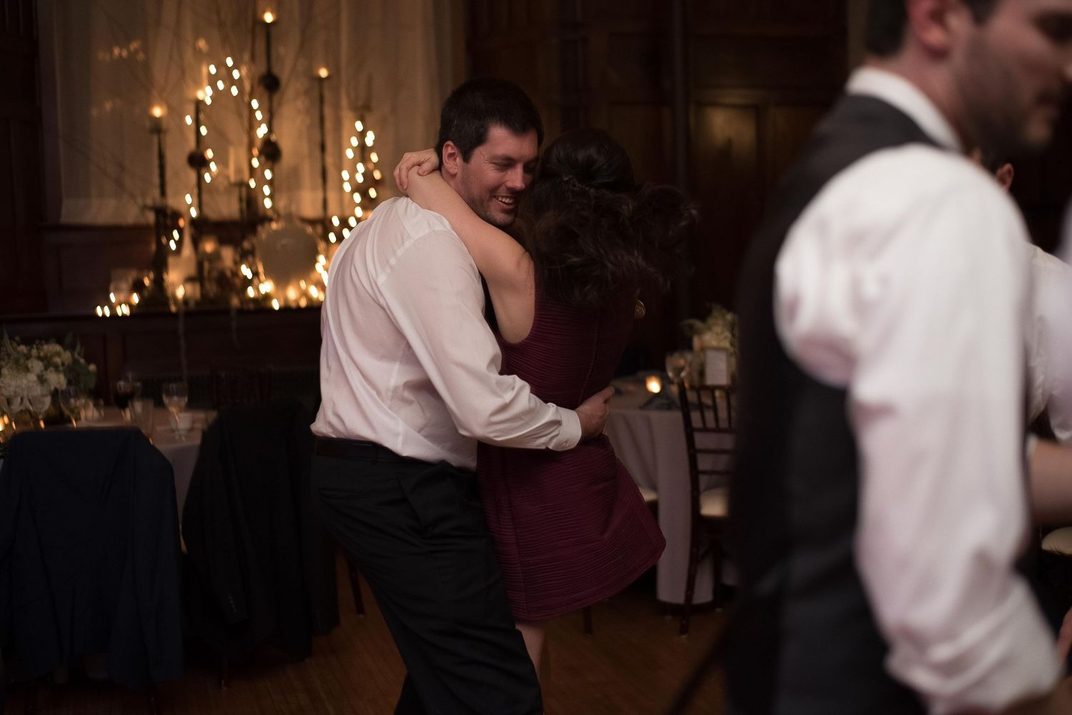 Couple shares romantic slow dance at elegant candlelit wedding reception venue.
