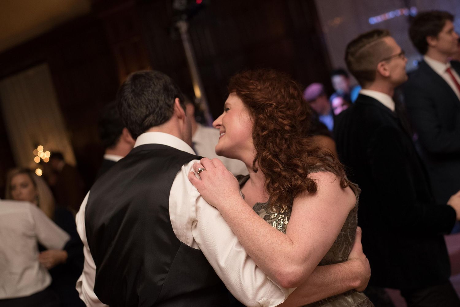 Couple sharing a romantic dance embrace at a wedding reception in an elegant ballroom setting.
