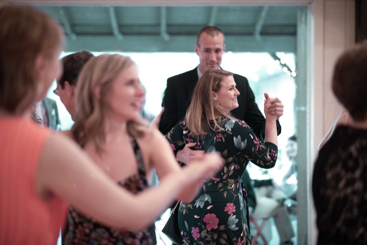 Guests dancing and socializing at an elegant indoor wedding reception party celebration.