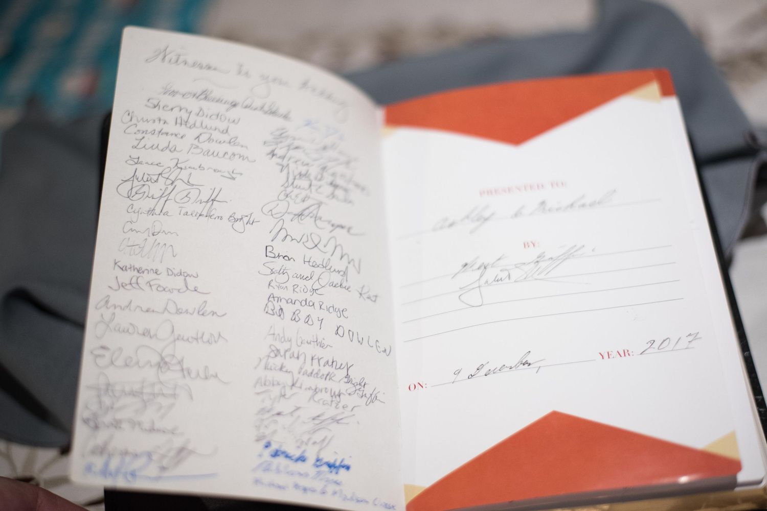 Open wedding guest book filled with signatures and handwritten messages on white pages.
