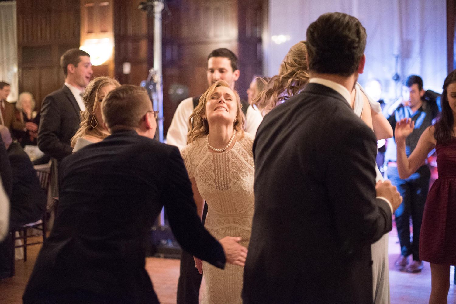 Guests dancing and celebrating joyfully at an elegant indoor wedding reception venue.