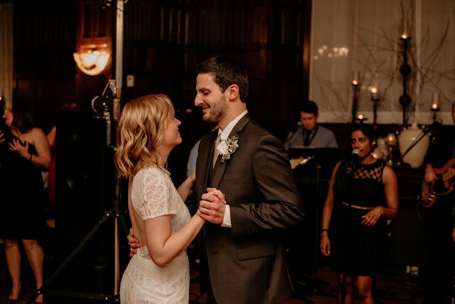 Bride and groom share a romantic first dance at their wedding reception with a live band.