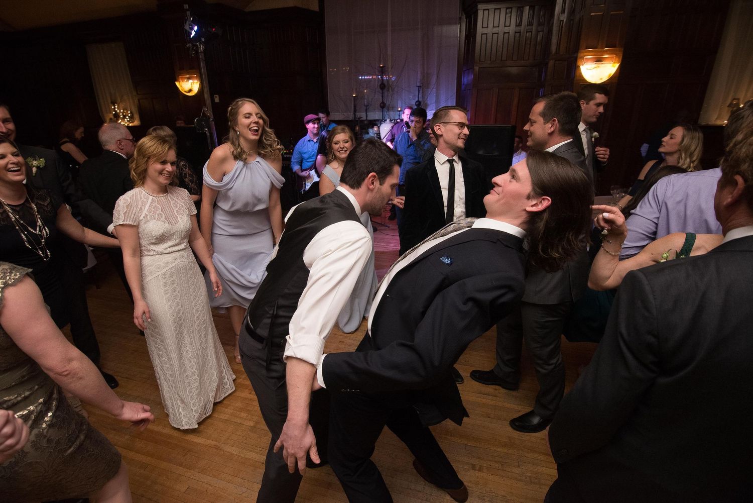 Guests dancing energetically at a formal wedding reception in an elegant ballroom venue.