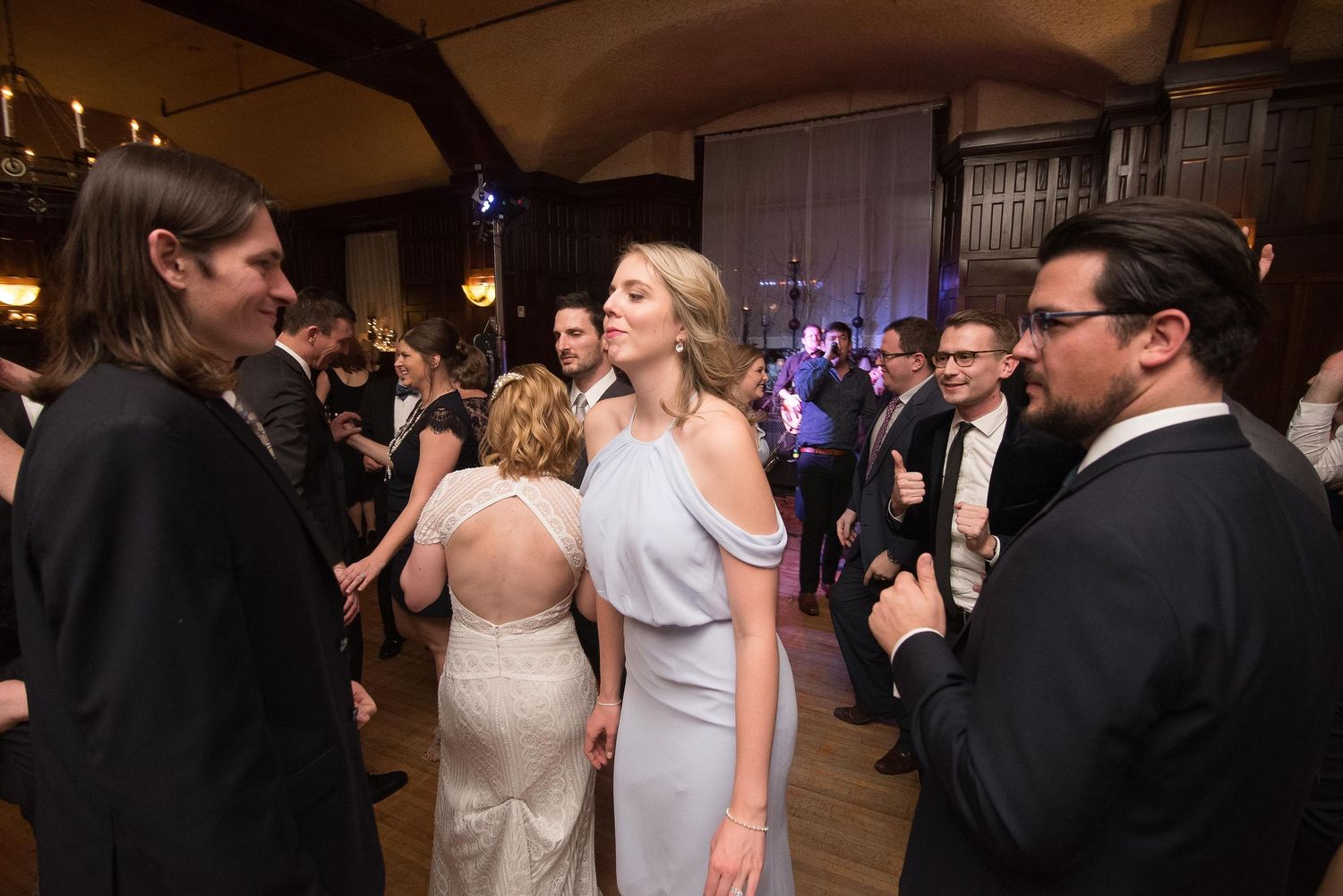 Elegantly dressed guests socializing at a formal evening gala in a grand ballroom.