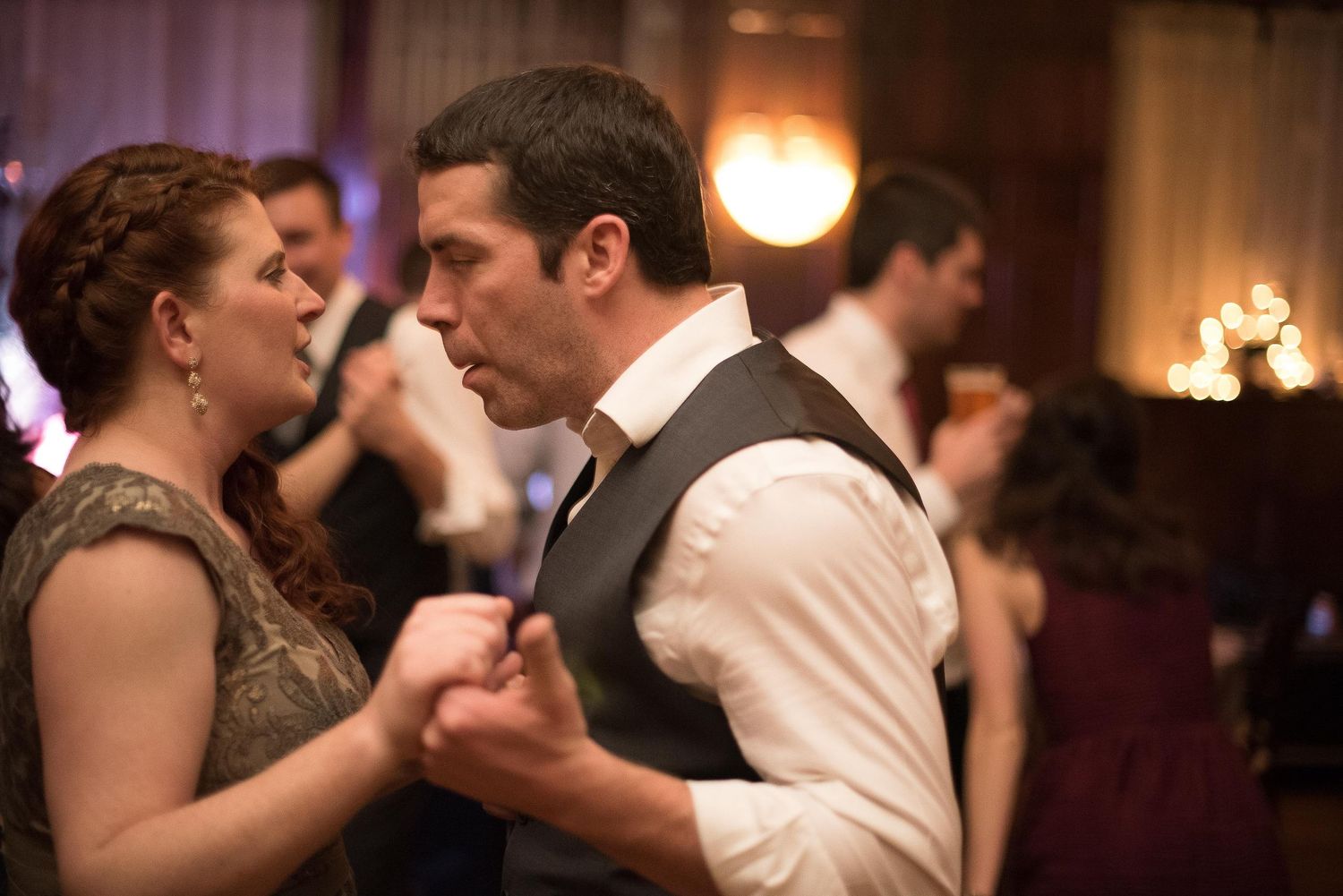 Couple dancing closely together at a formal event, with other guests dancing in the background.
