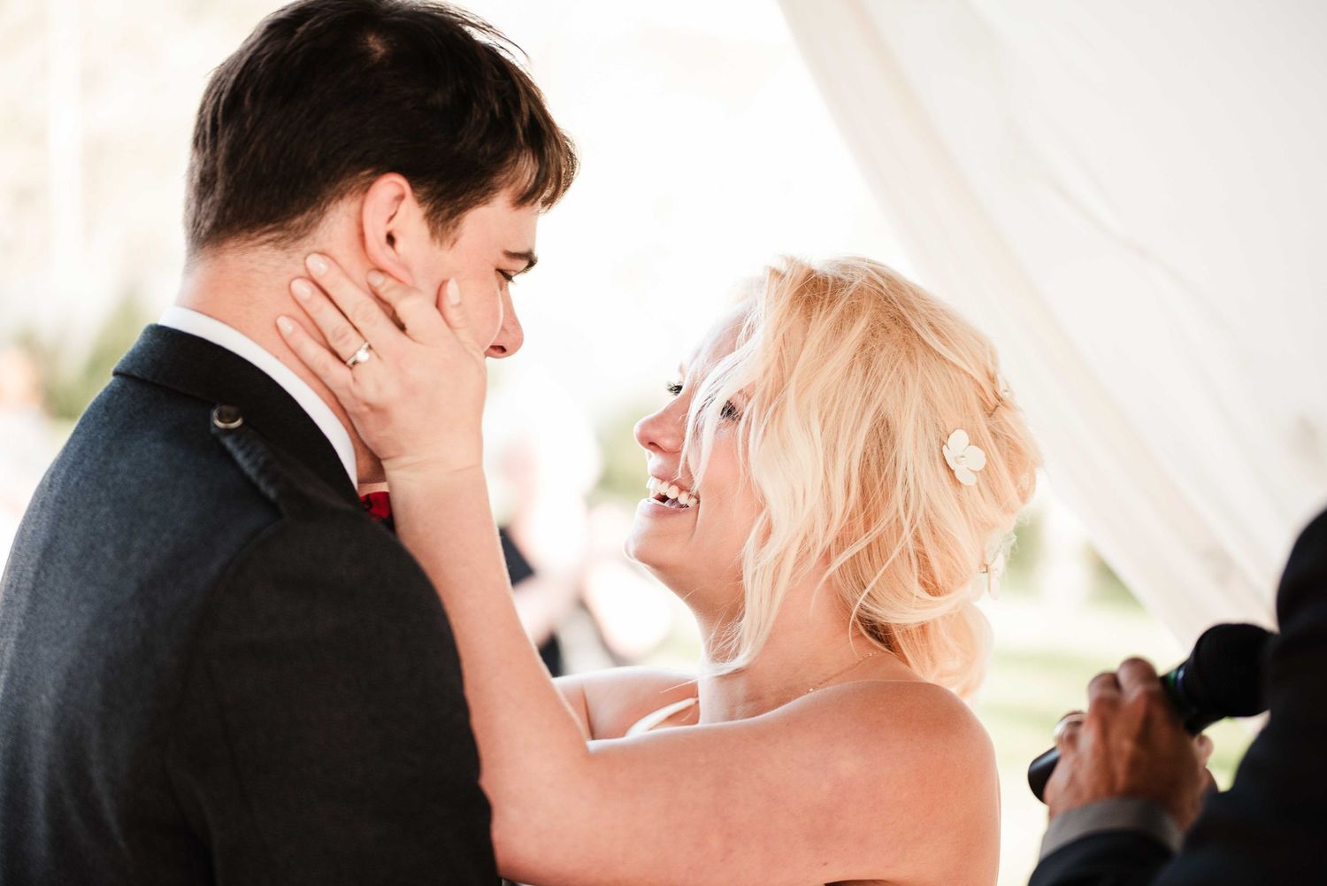 Bride and groom share a romantic first dance, smiling closely together at their elegant wedding reception.