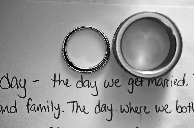 Two wedding rings rest on handwritten wedding vow letter.
