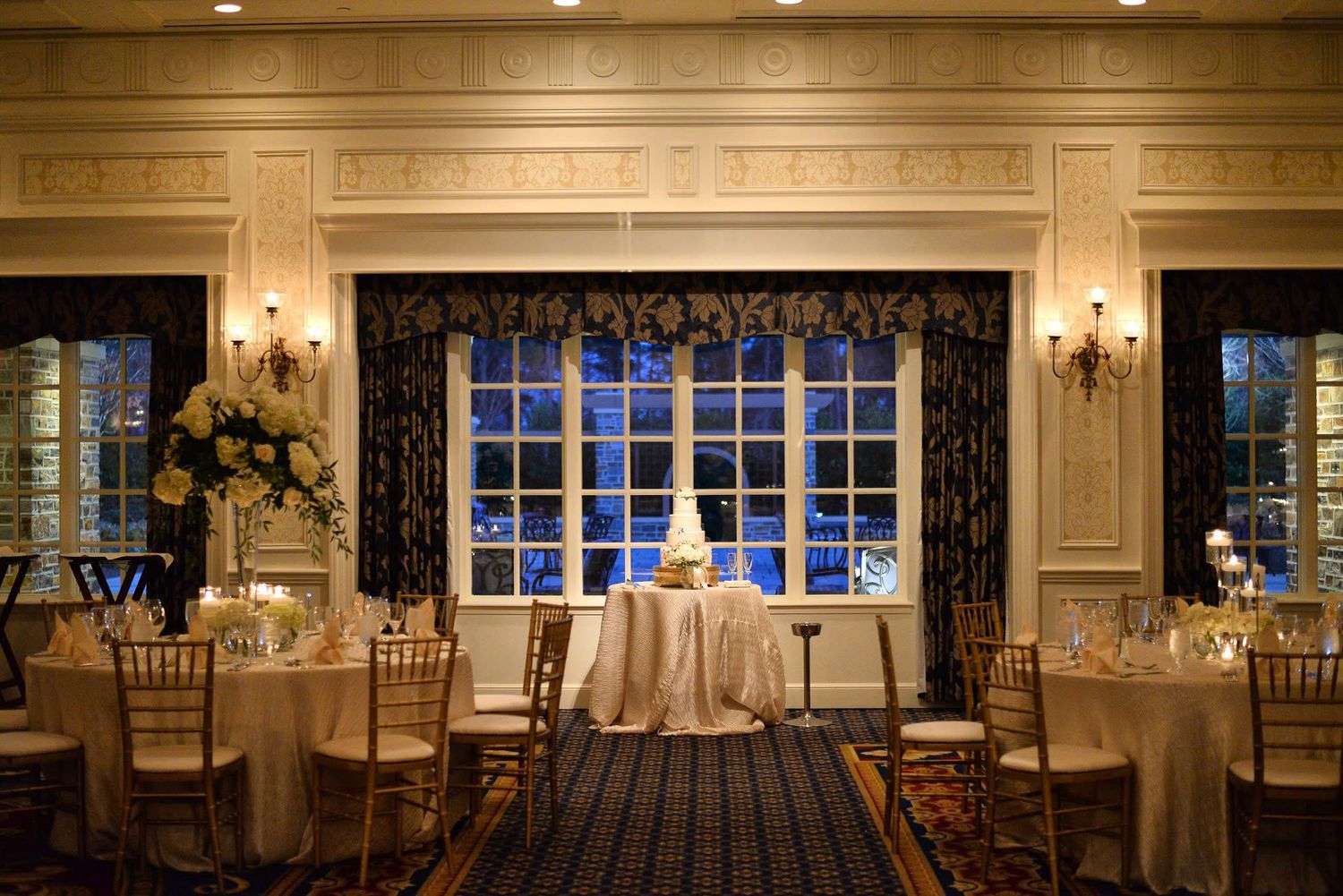 Intimate wedding reception room with elegant decor and blue night window.