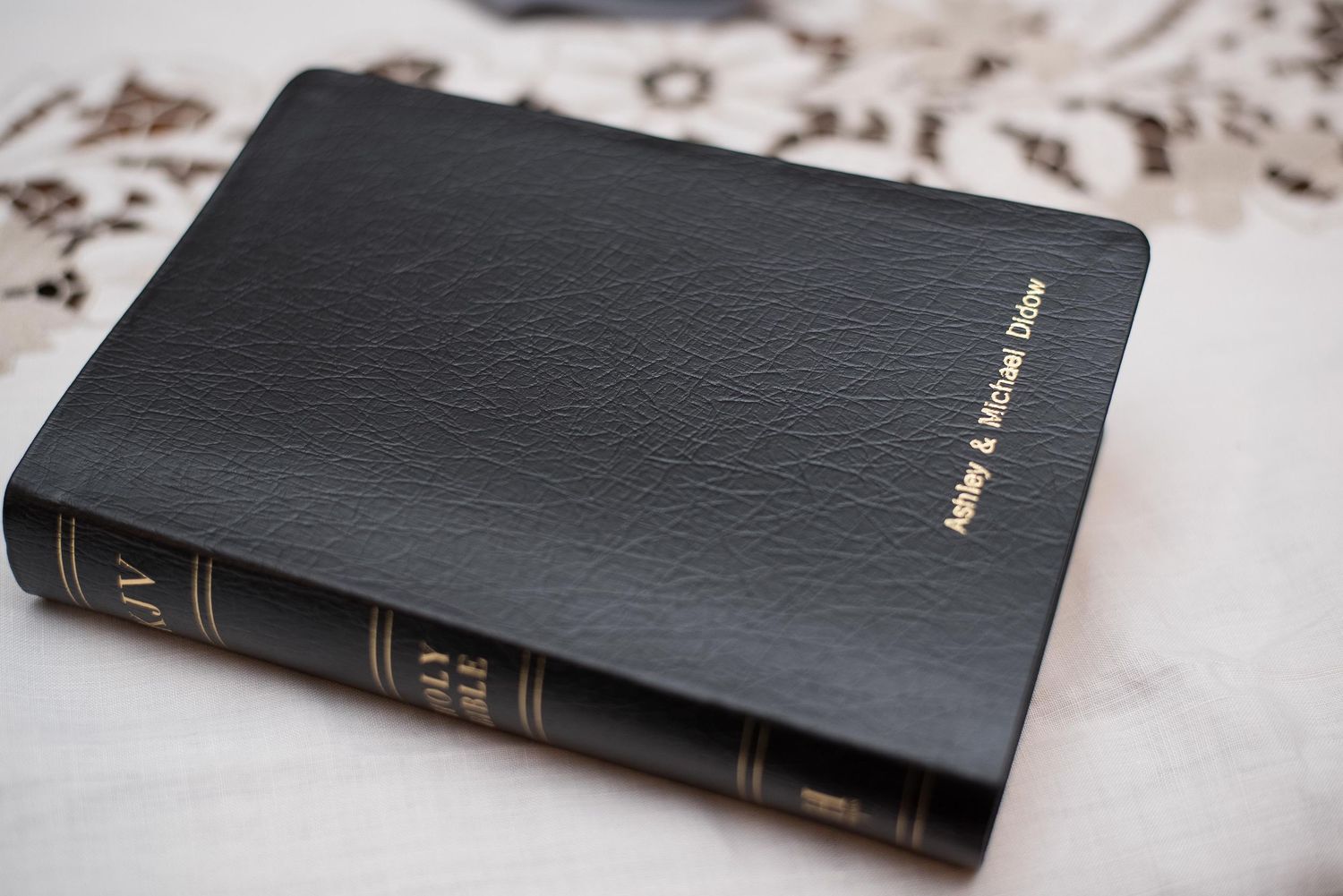 Black leather personalized Bible with gold embossed names on the cover.