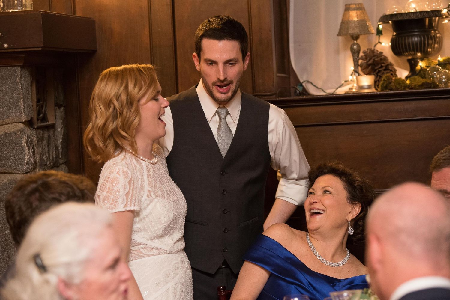 Guests laughing and conversing at a formal wedding reception in an elegant venue.