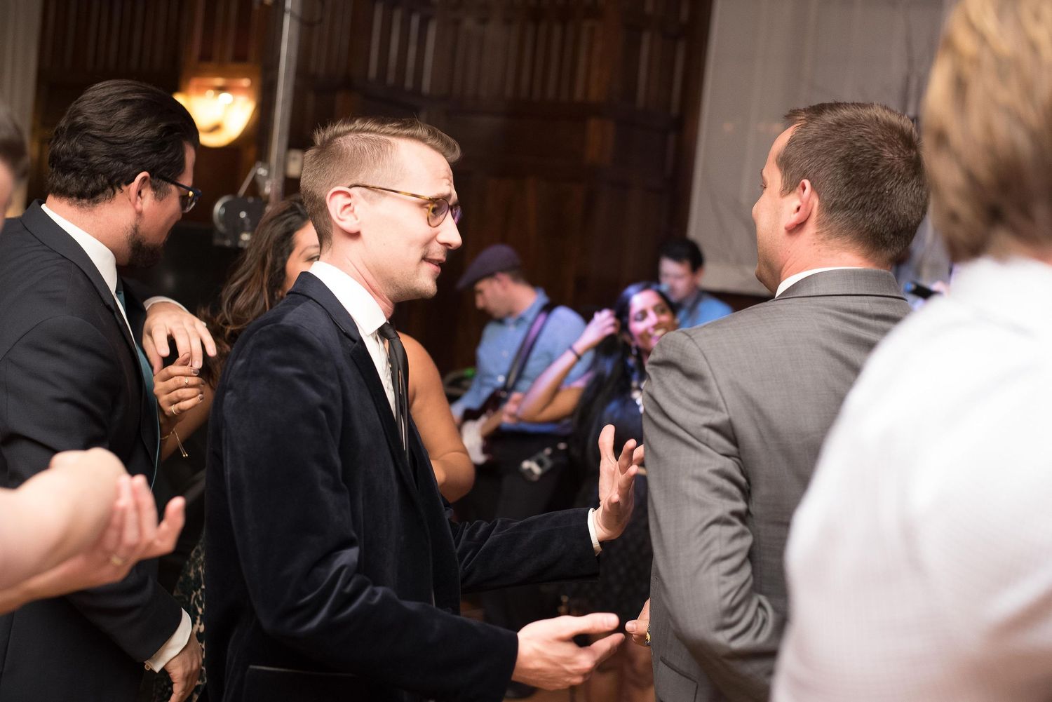 Guests mingling and socializing at an elegant indoor wedding reception in formal attire.