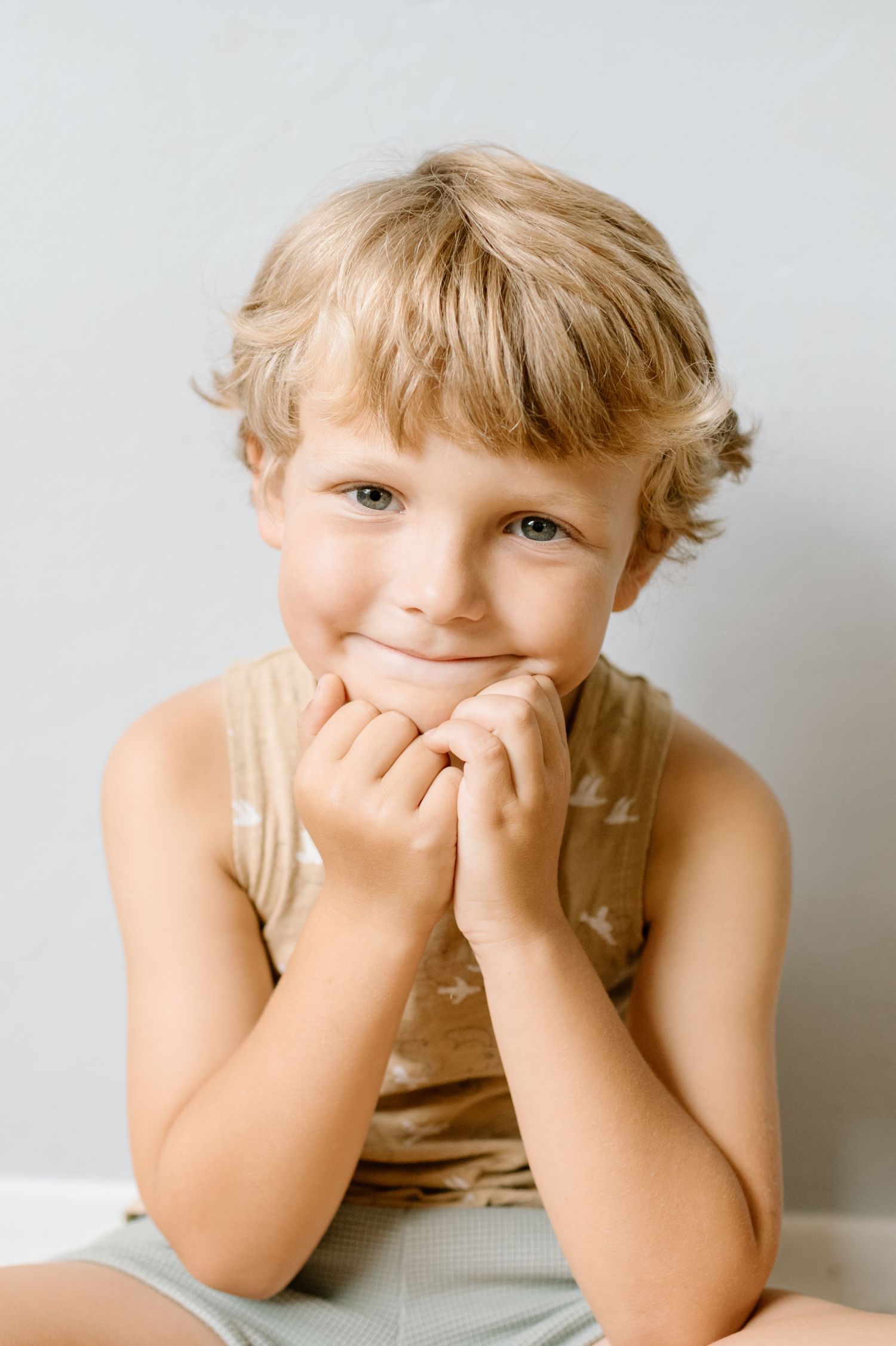 Young boy poses for camera during at home family photoshoot in San Diego.