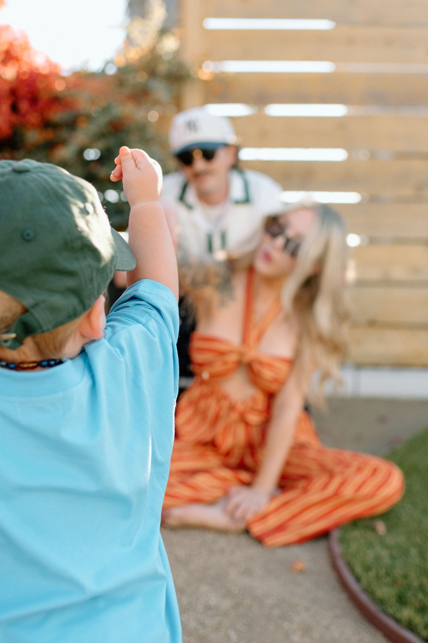 A split sequence photo showing a child in blue shirt playing outdoors with someone in an orange dress.