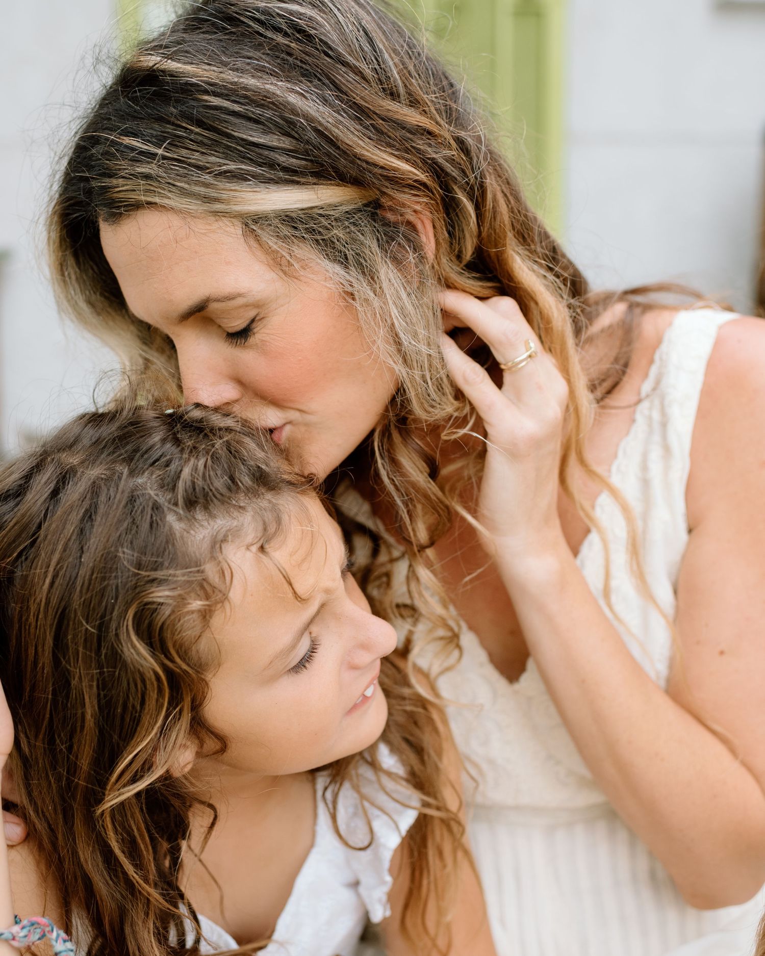 Mom kisses daughter during at home family photoshoot in San Diego.