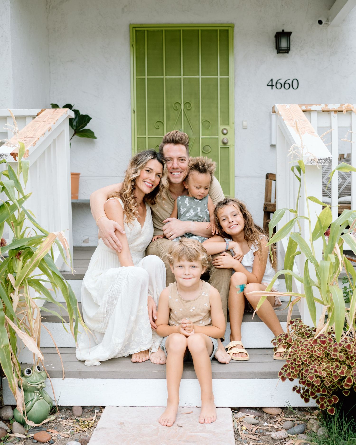Family posing on porch during at home family photoshoot in San Diego