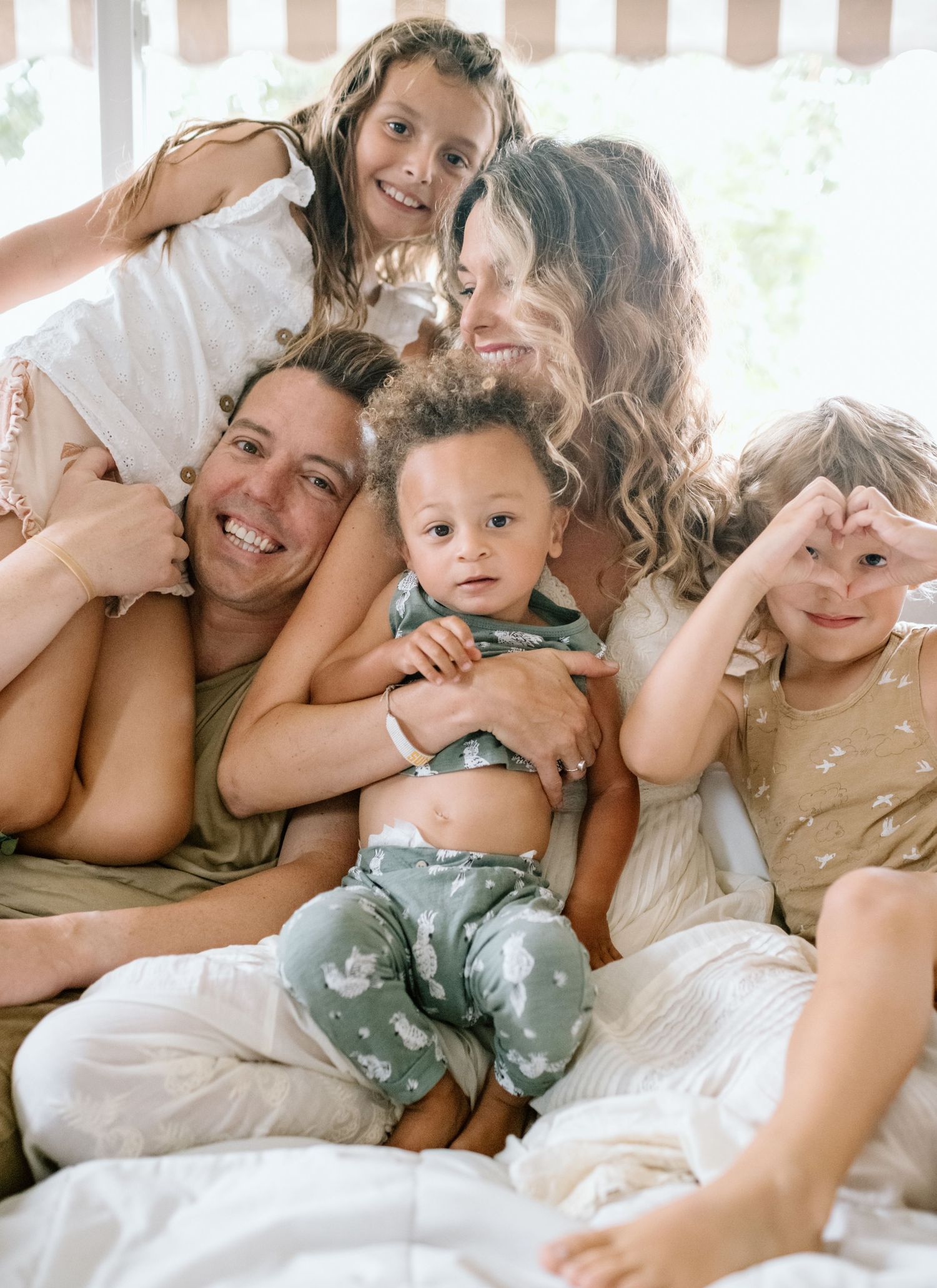 Family snuggled on couch during at home family photoshoot in San Diego