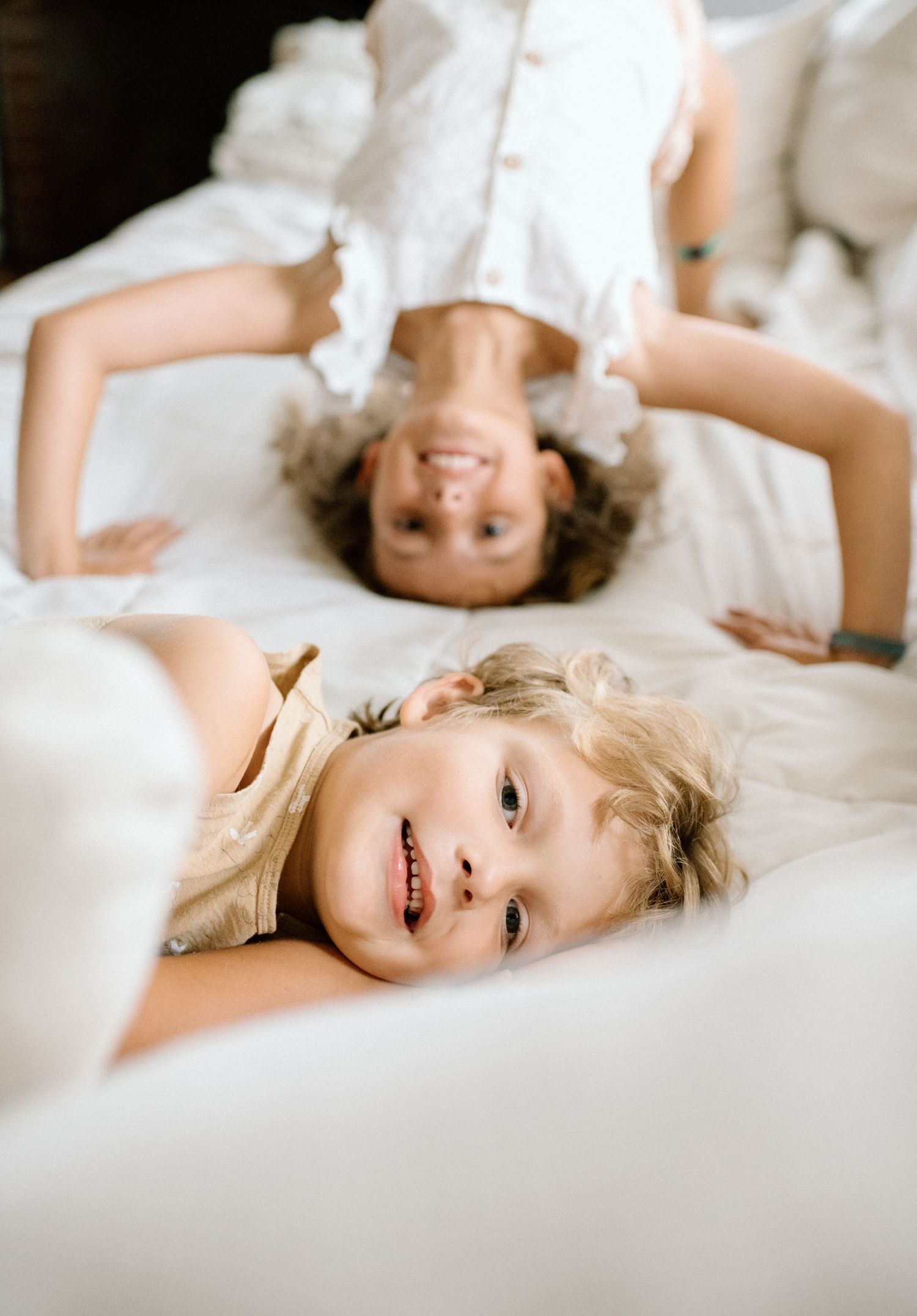 Two siblings being silly on the couch during at home family photoshoot in San Diego