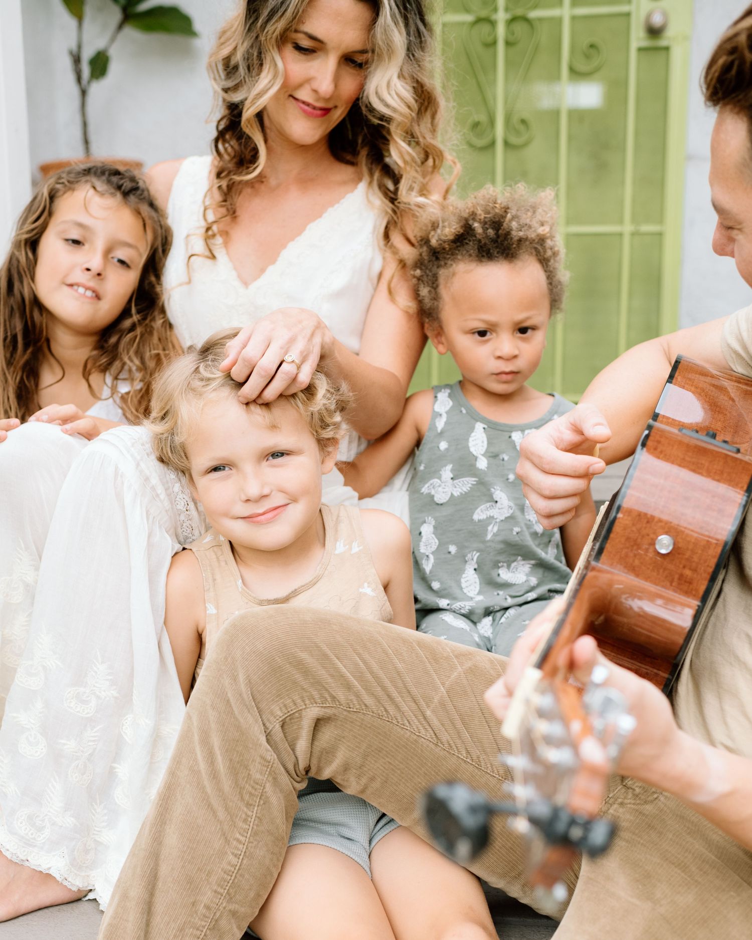 Family playing guitar during at home family photoshoot in San Diego
