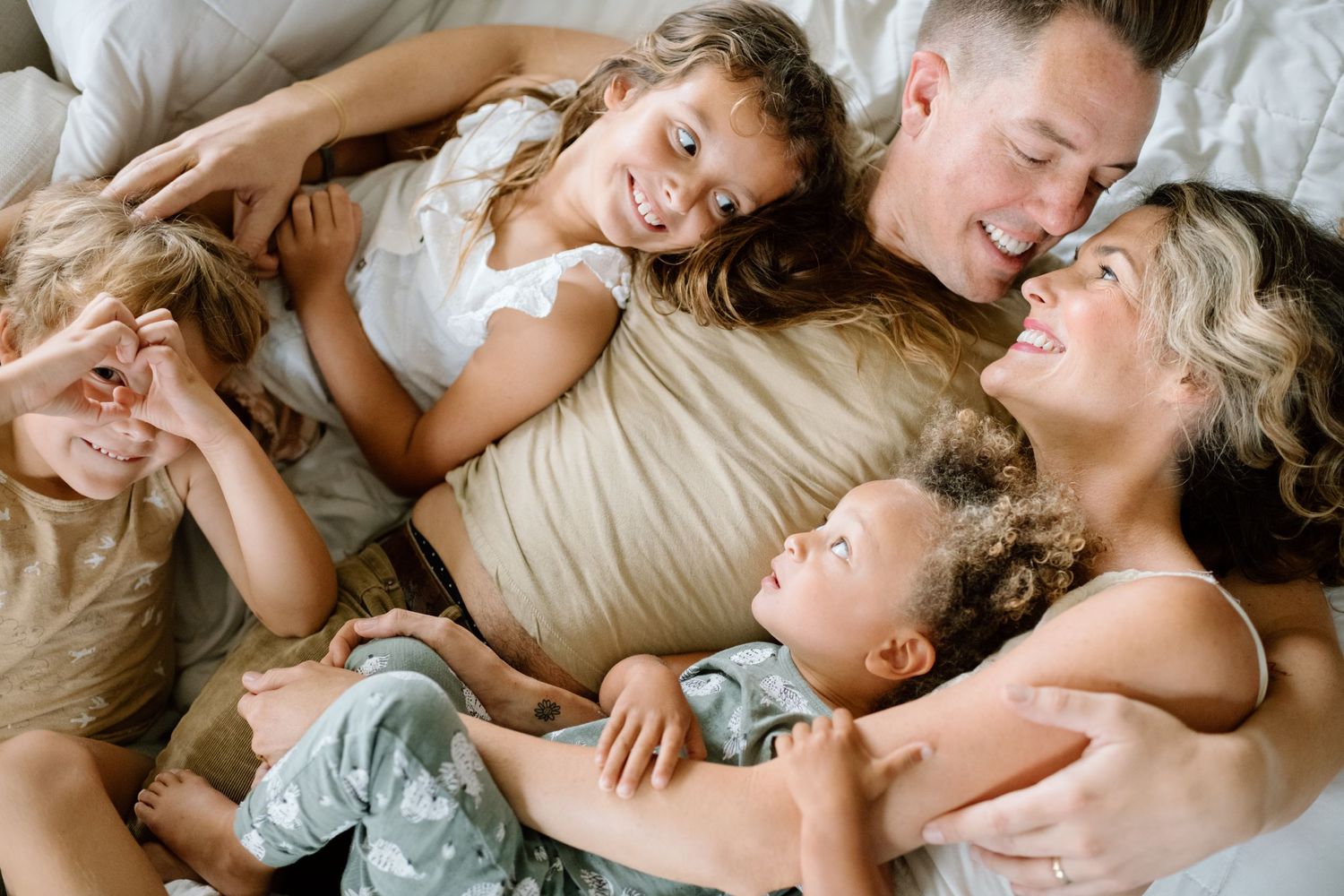 Family lying down on couch during at home family photoshoot in San Diego