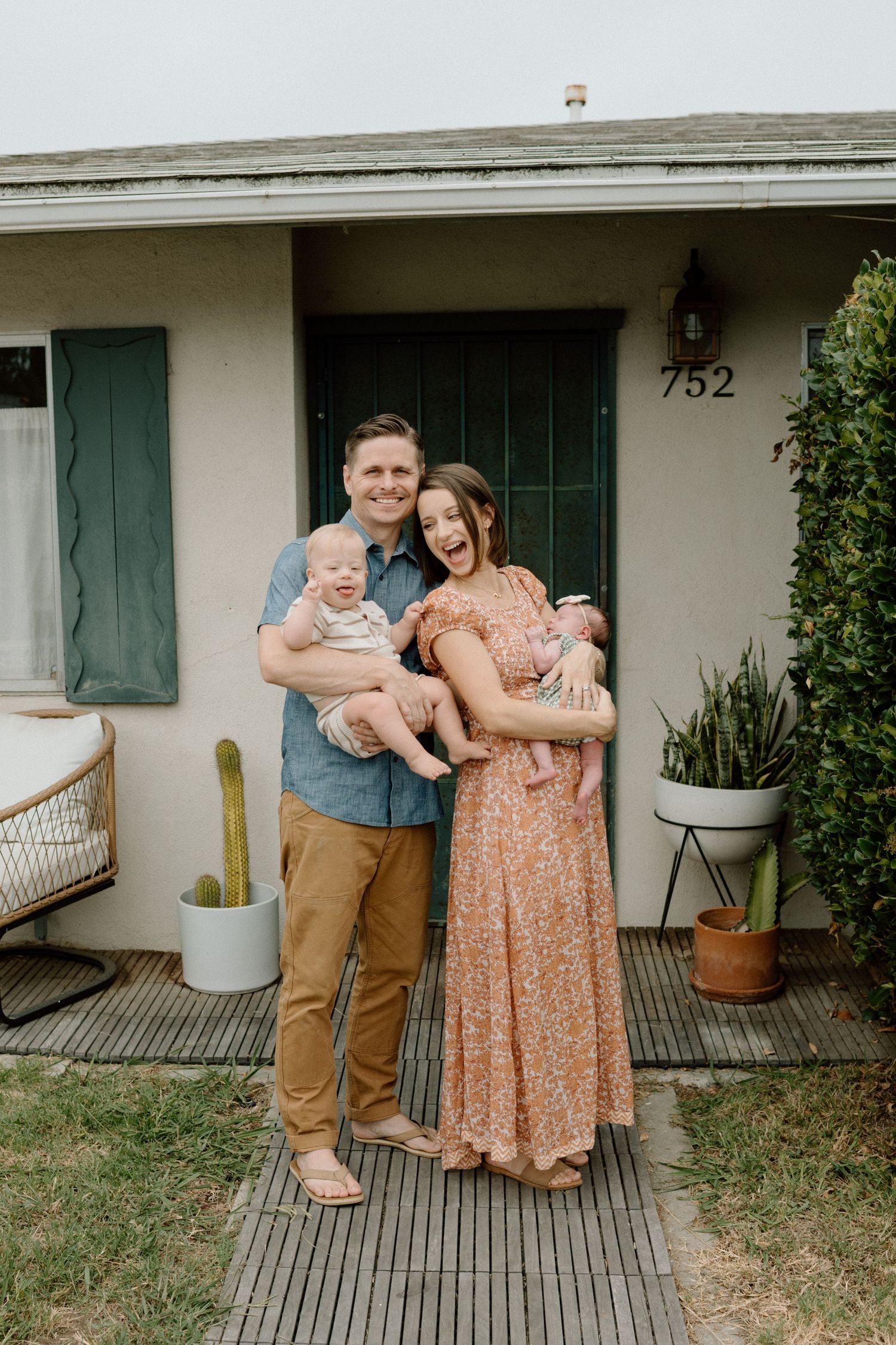 Happy young family with two babies posing in front of their home at house number 752.