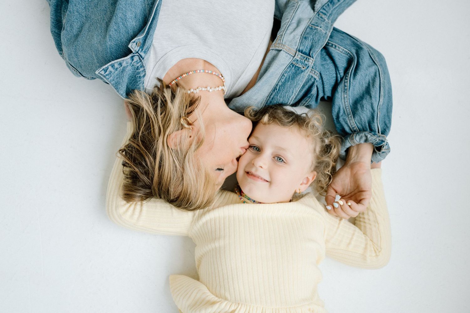 Mother and daughter lying together sharing a sweet tender moment.
