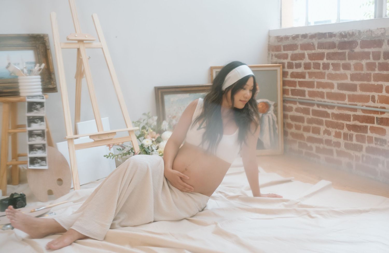 Pregnant woman lounges during maternity photoshoot in a San Diego studio.
