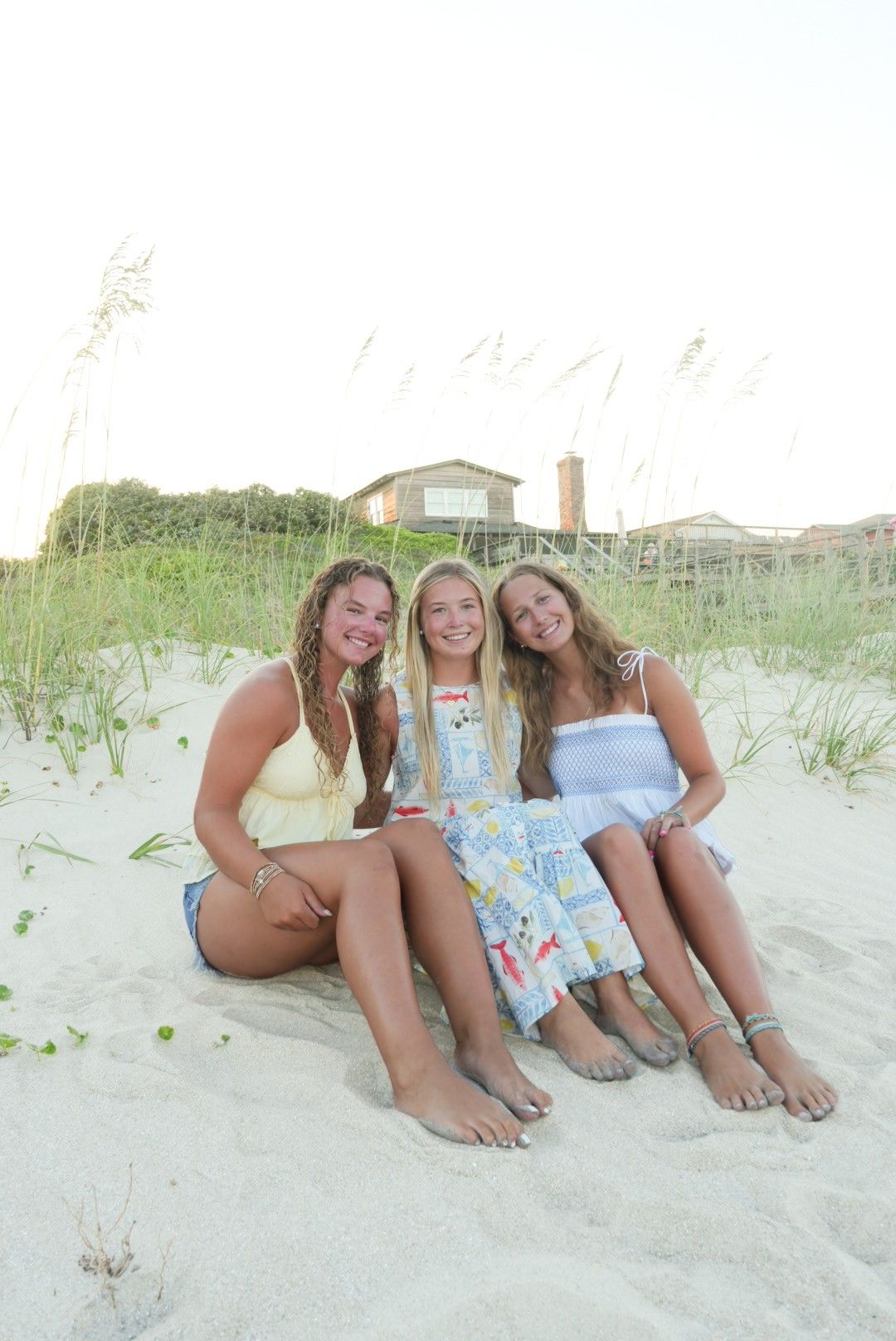 Friends sitting on the beach during a photoshoot in South Carolina.
