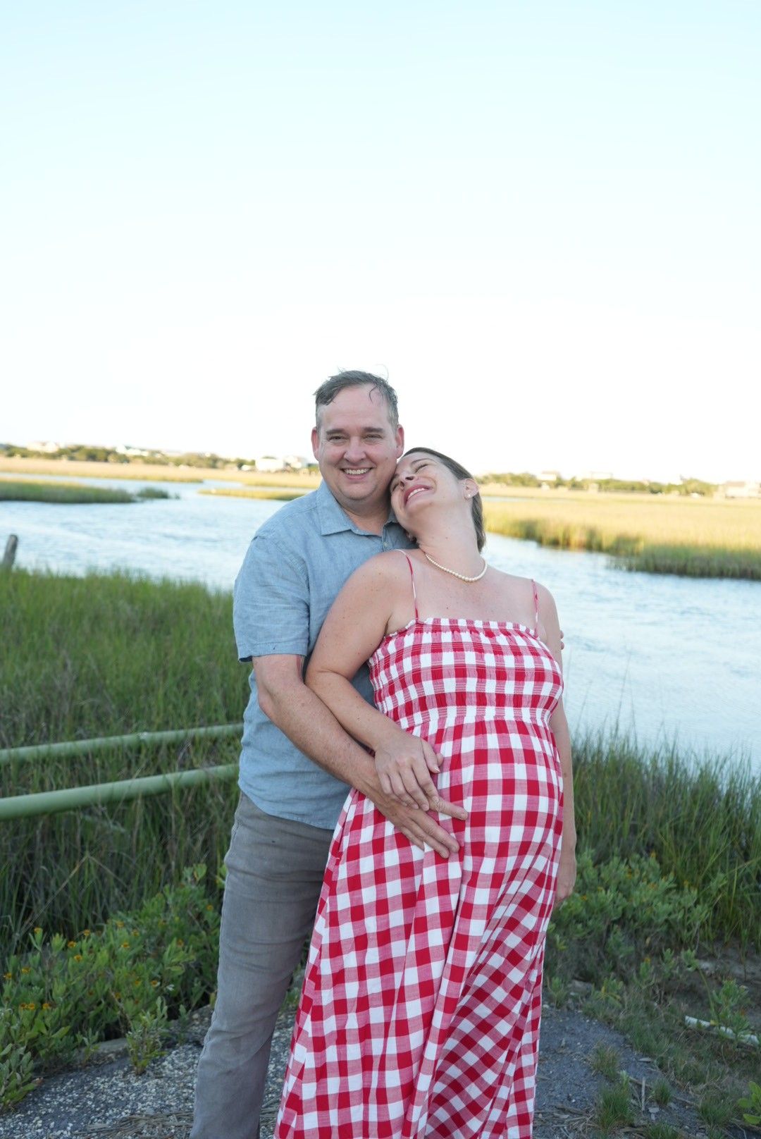 Couples portrait in front of a marsh taken by a photographer in Pawleys Island, South Carolina.