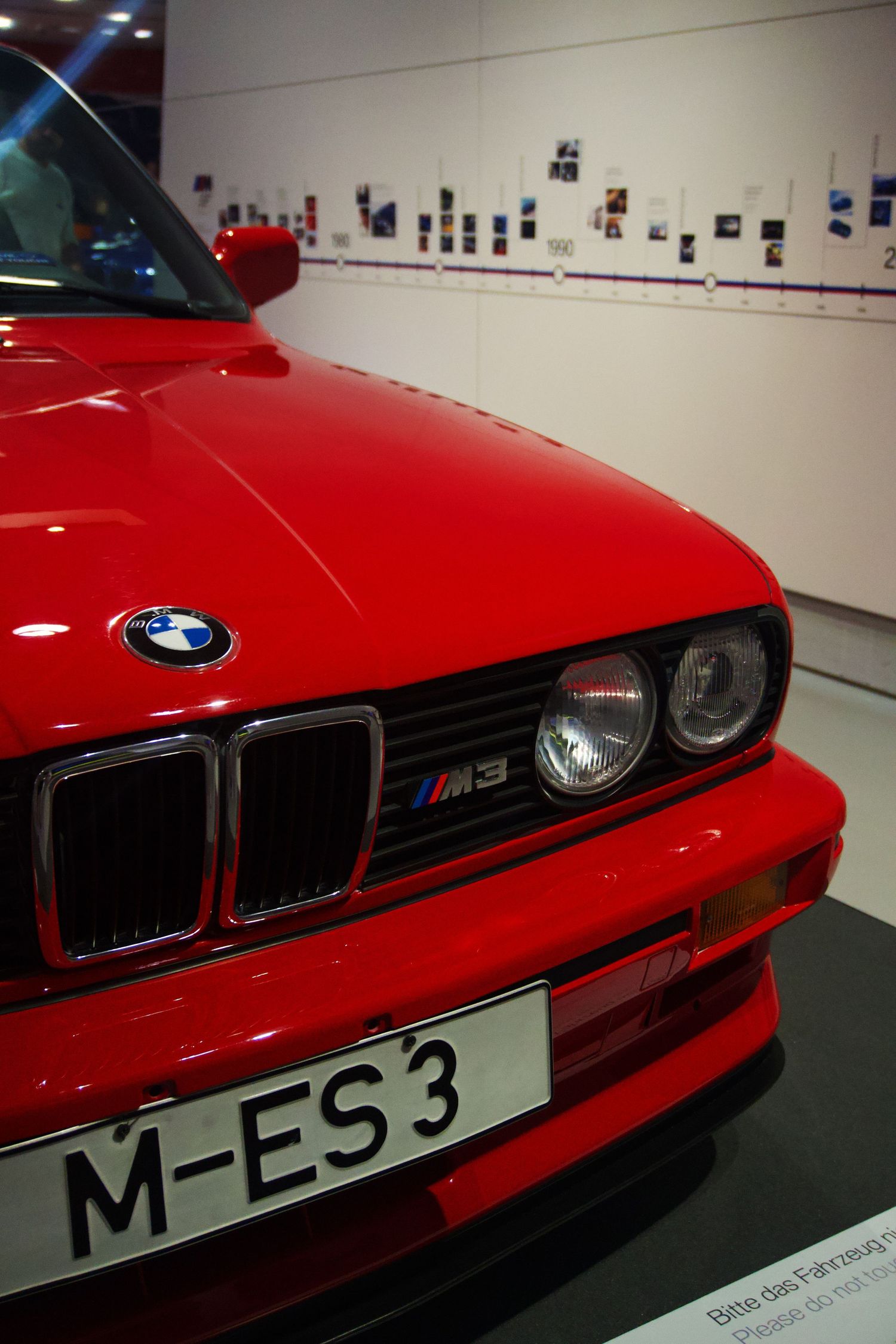 Classic red BMW M3 E30 on display at museum with license plate M-ES3.