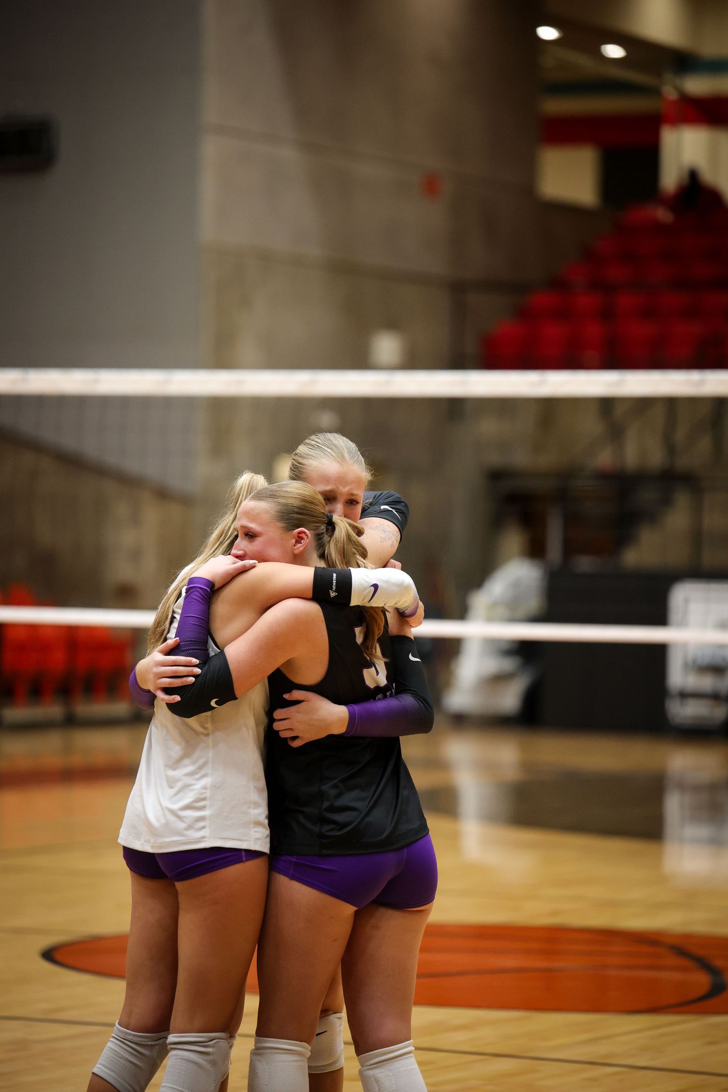 R.L. Paschal High School seniors hug and cry after a varsity volleyball win in a playoff game, continuing their season.