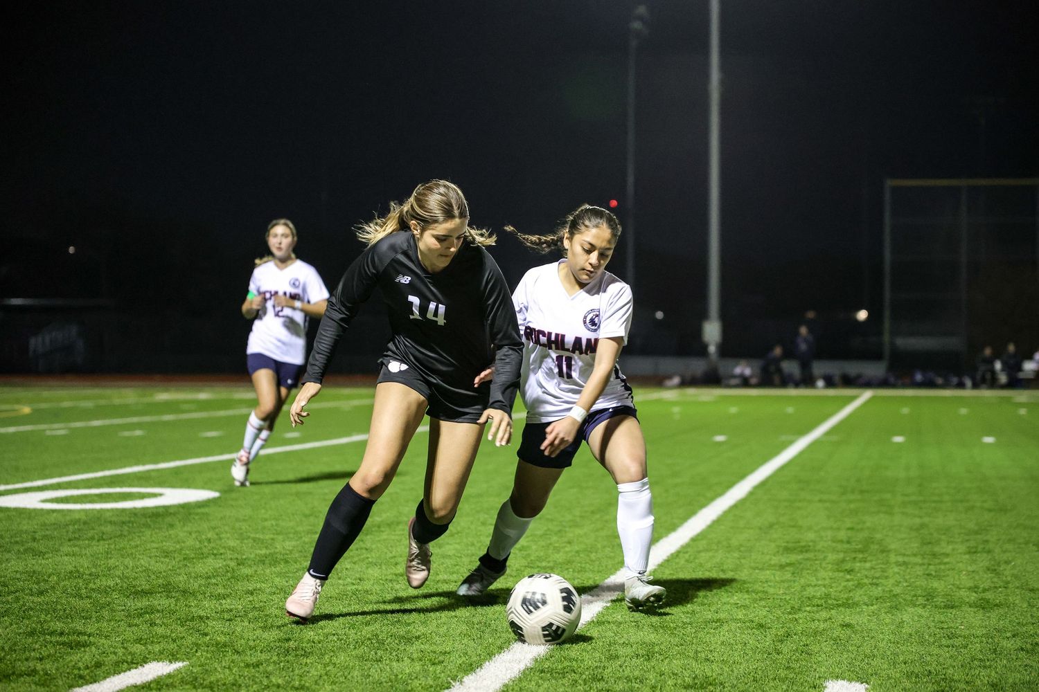 R.L. Paschal High School's Varsity Girls Soccer player remains in possession of the ball during a tense play in the game.