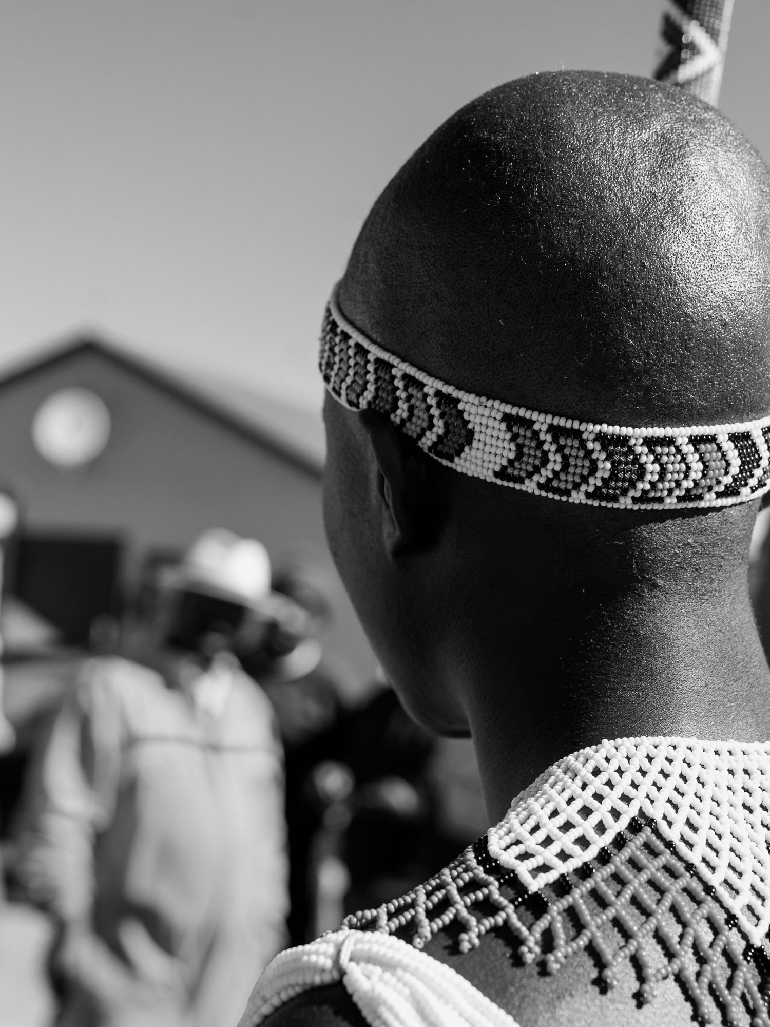 Back view of a person wearing traditional Zulu beaded headband and beaded necklace in black and white. Event Photography