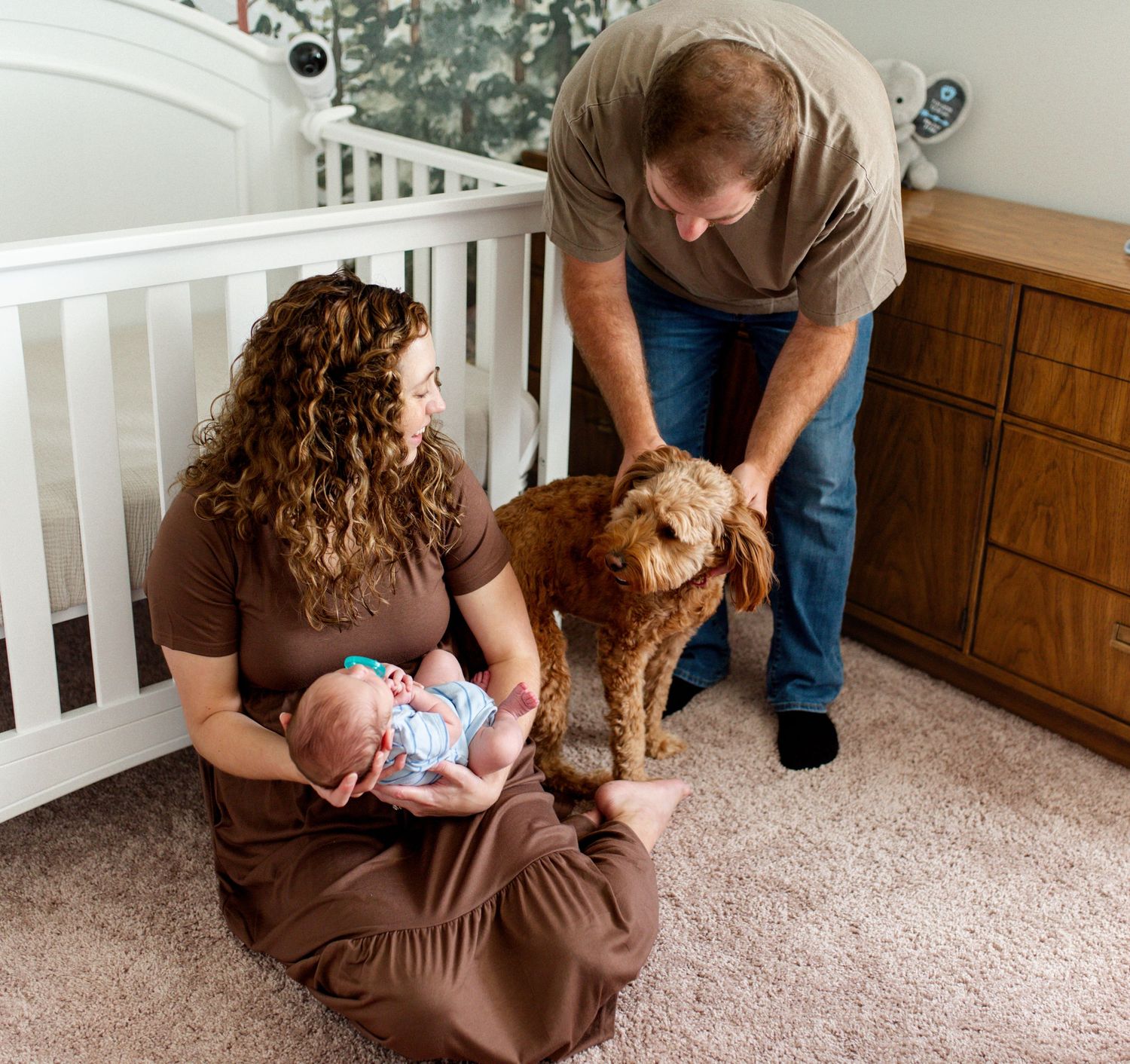 St. Charles County Newborn Photography. Mom and dad sit with baby and dog.