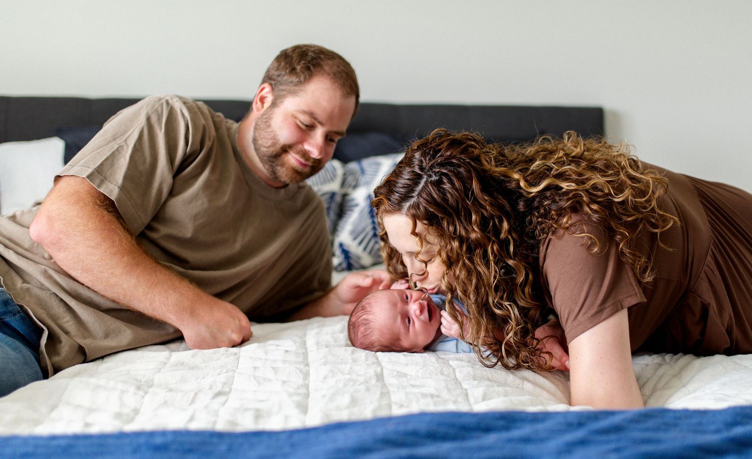 mom kisses baby during lifestyle newborn photography session